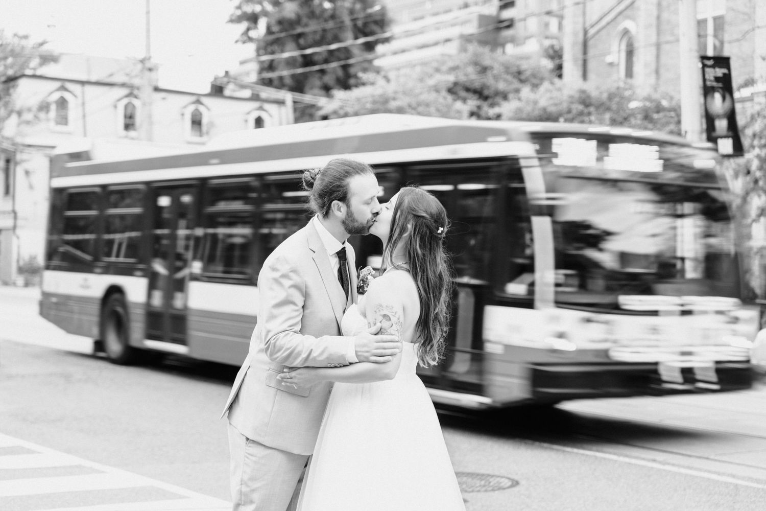 Person waits at bus stop in black and white photo series showing public transit scenes.