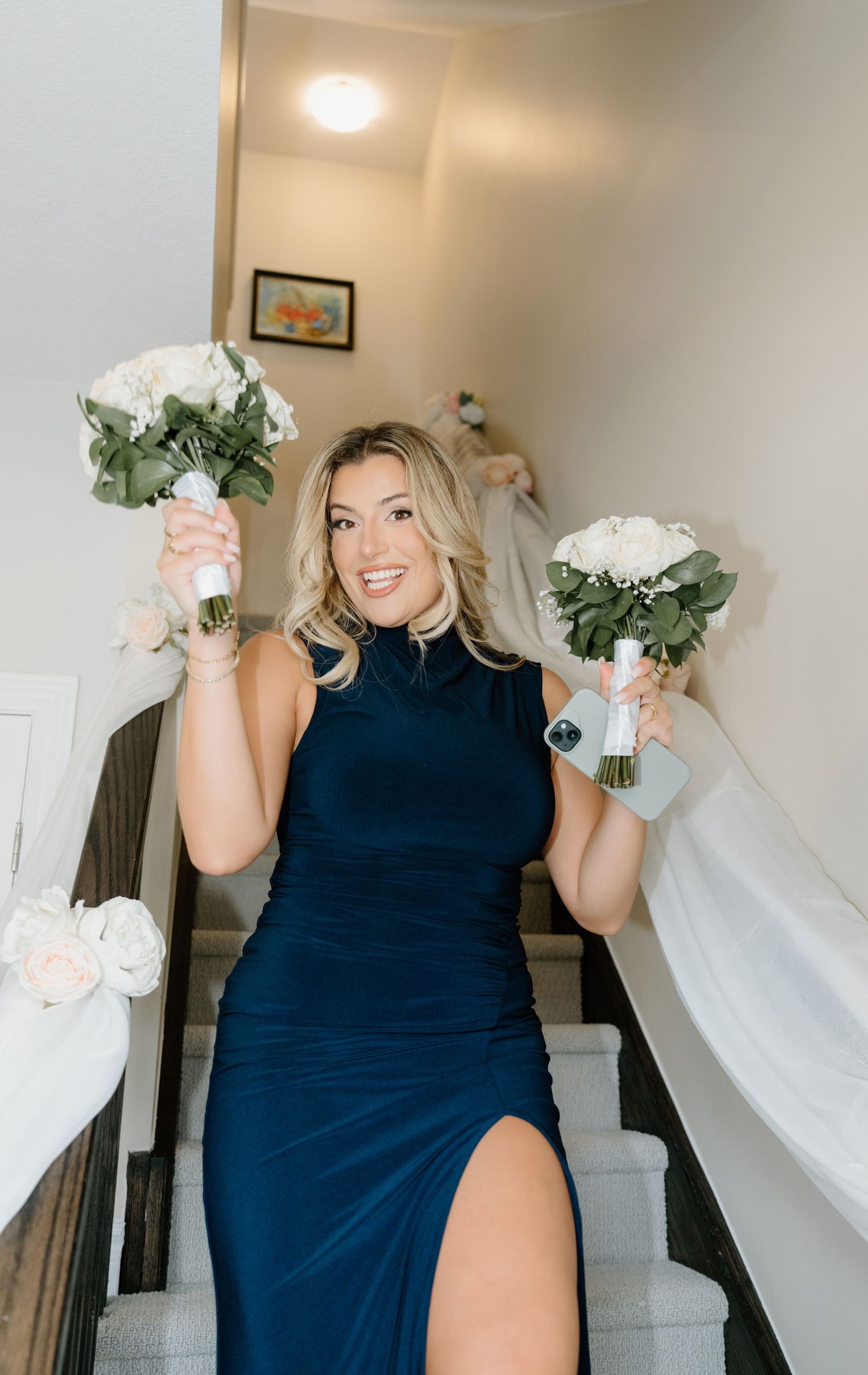 A person in a navy blue dress holds up a white bouquet while posing in a series of four similar photos.