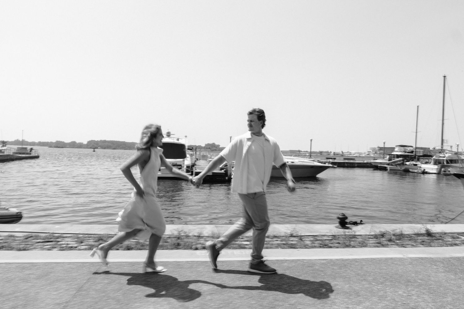 A sequence of black and white photos shows people walking along a beach boardwalk with their shadows stretching behind them.