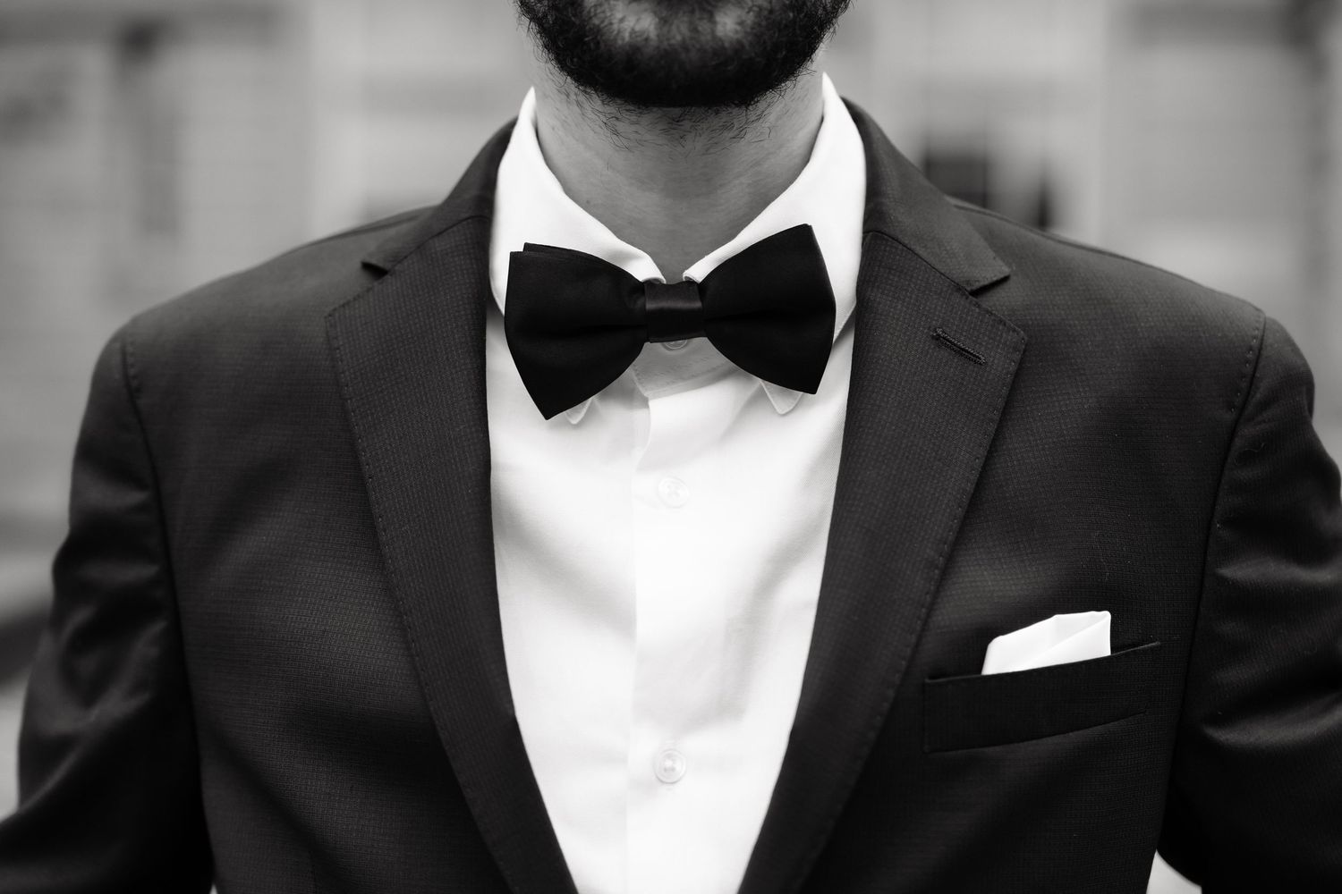 Close up detail of a formal black tuxedo with white shirt and black bow tie.