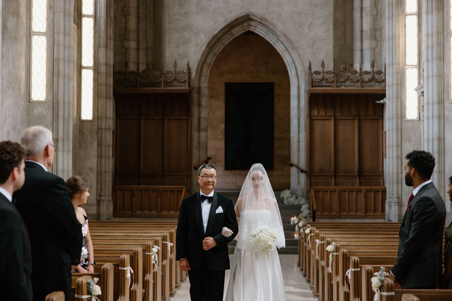 Black and white photo showing a romantic moment between a couple during a traditional church wedding ceremony.