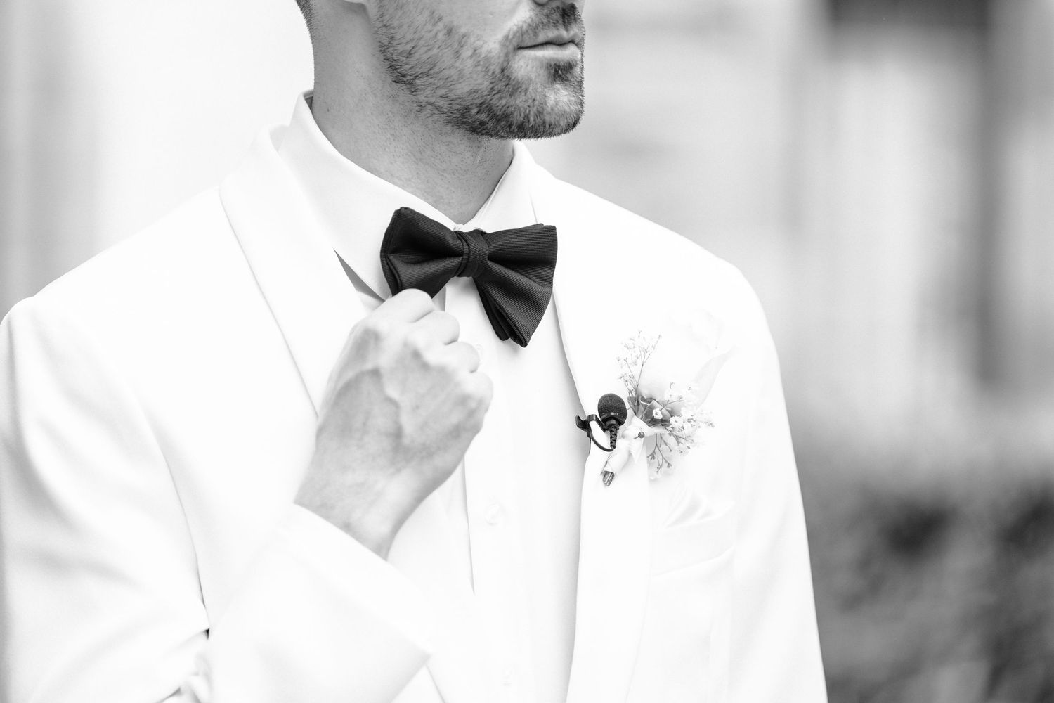 Elegant black and white photo of groomsmen in formal attire at a wedding ceremony.