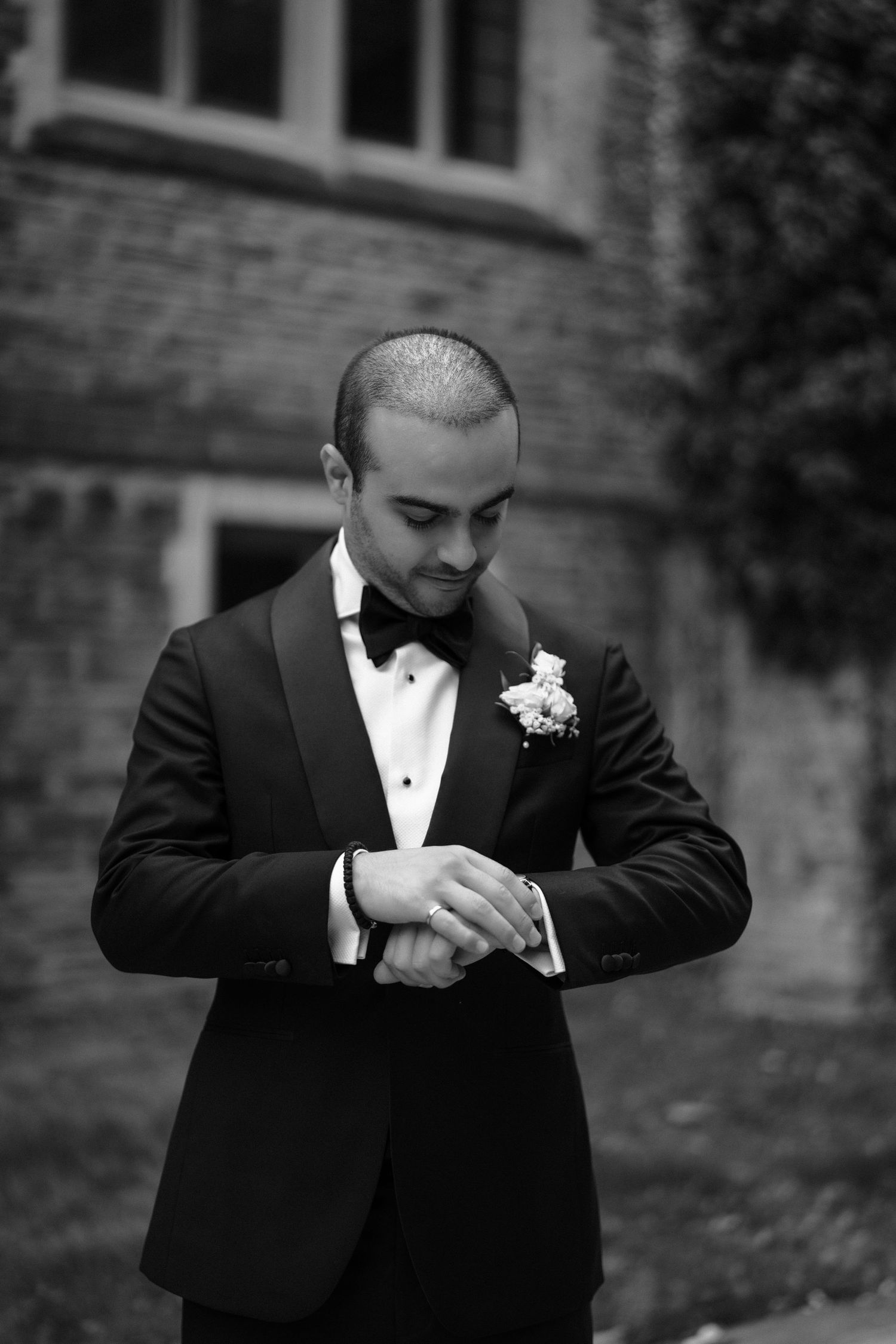 A black and white sequence of photos showing a person in a tuxedo adjusting their cufflinks and tie.