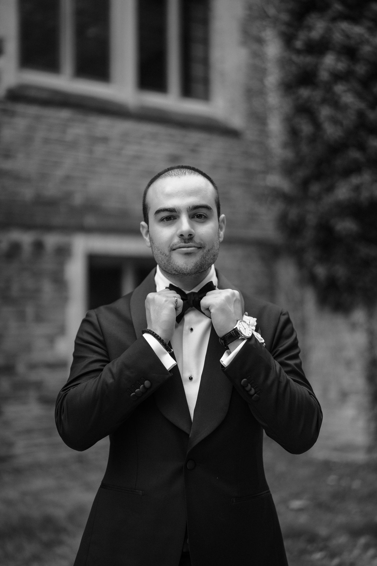 Black and white sequence showing a groom in tuxedo making playful gestures.