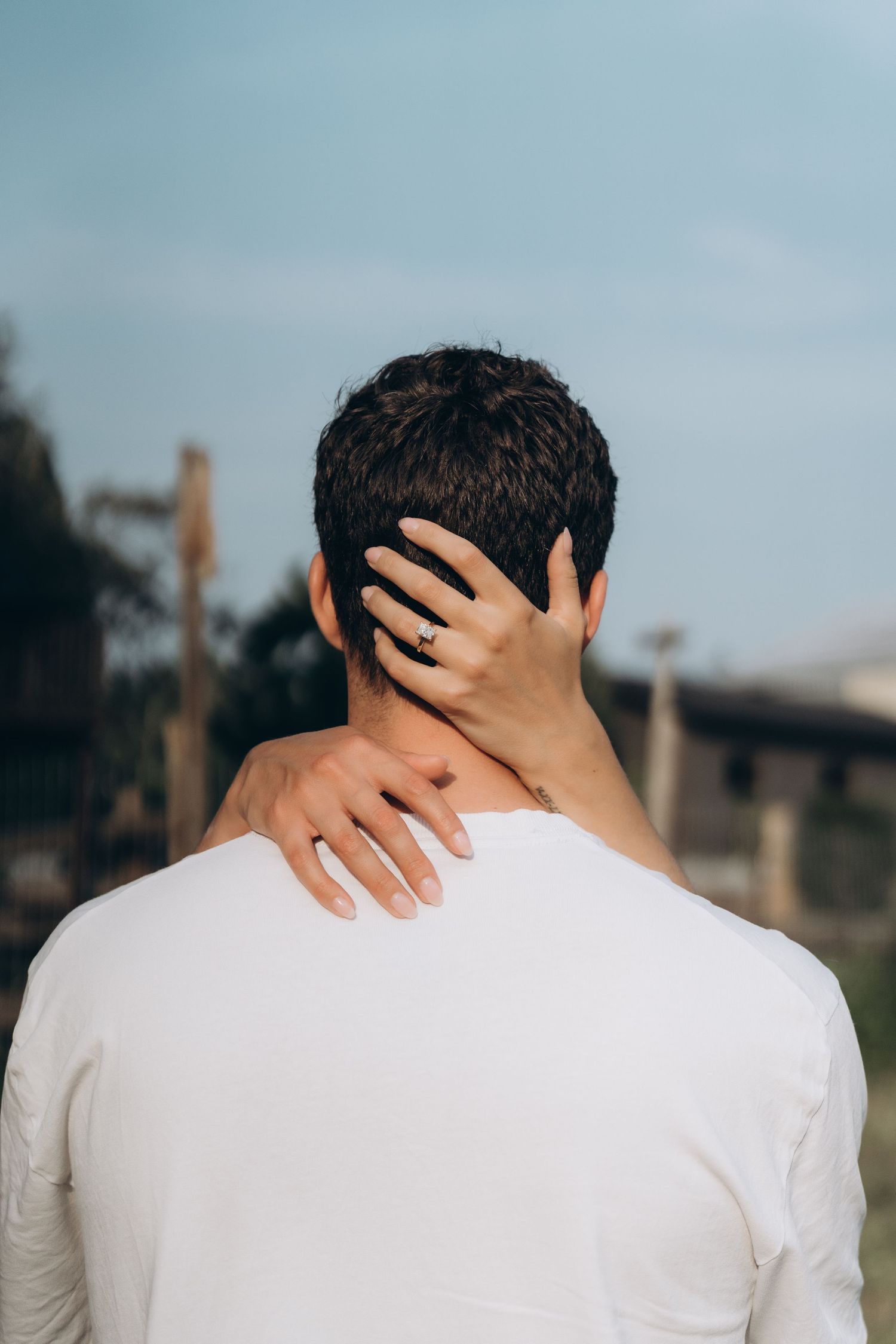 Person in white shirt shown from behind with hand placed on neck in multiple sequential poses.