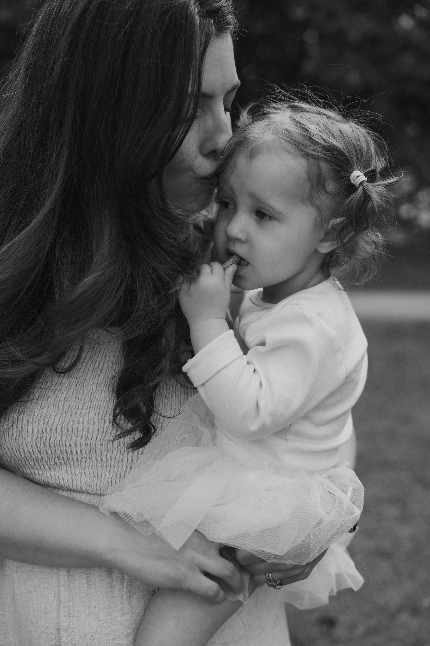 Black and white images show tender moments between parent and child embracing outdoors.