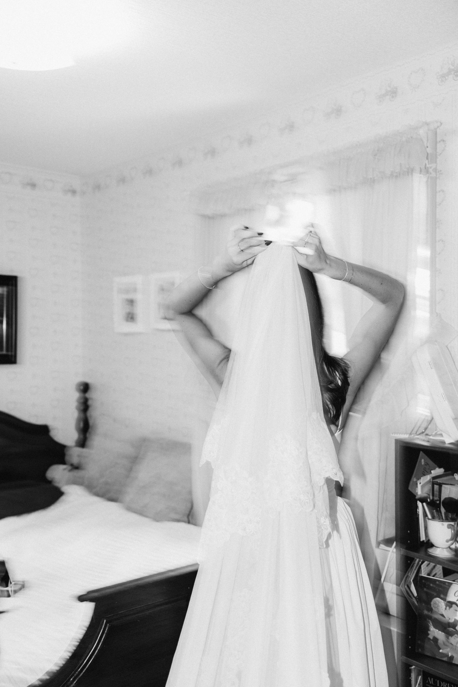 A series of black and white photographs showing wedding dresses hanging on walls in various minimalist interior settings.