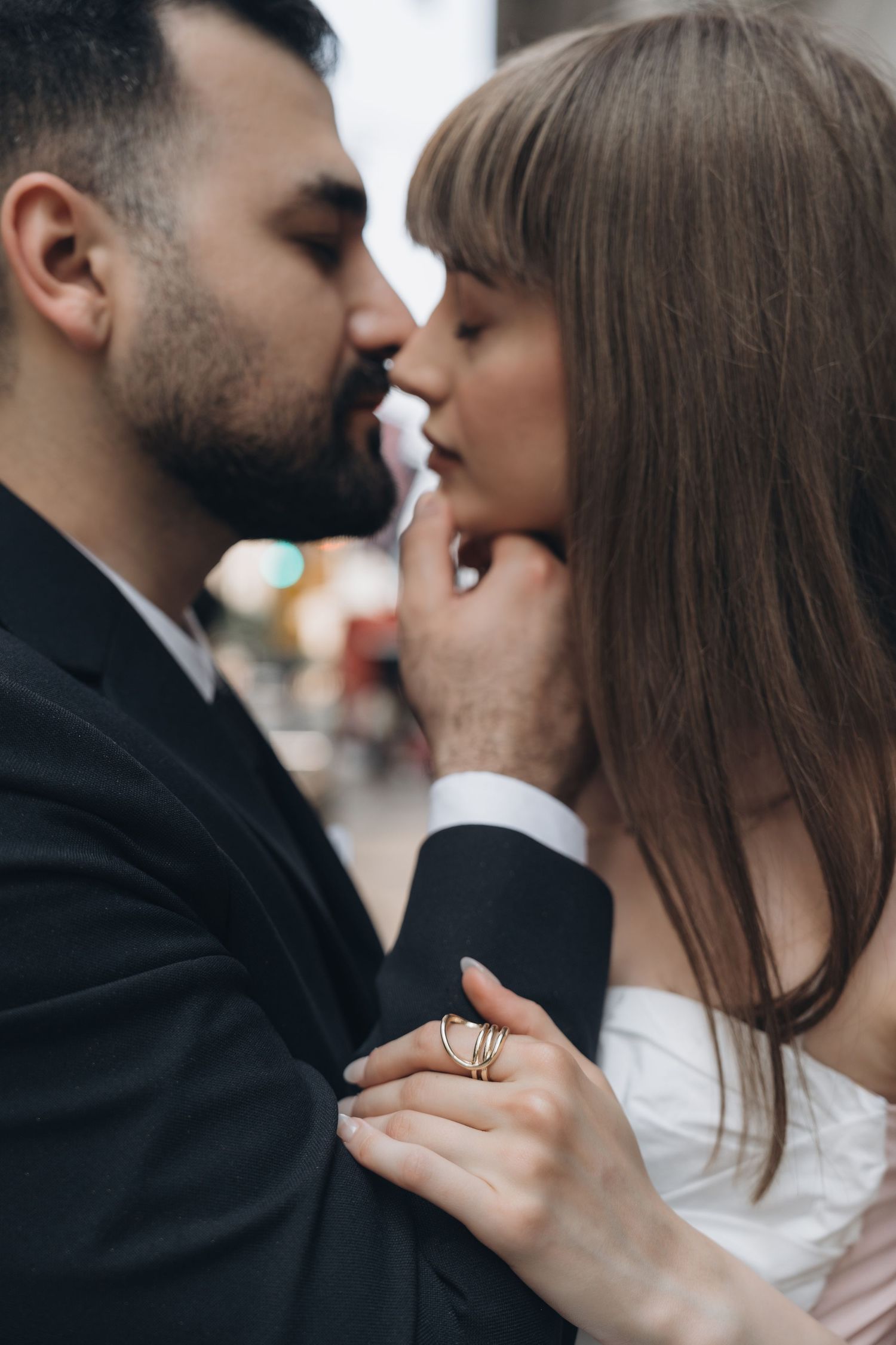 A romantic close-up moment between a couple in formal attire sharing an intimate kiss.