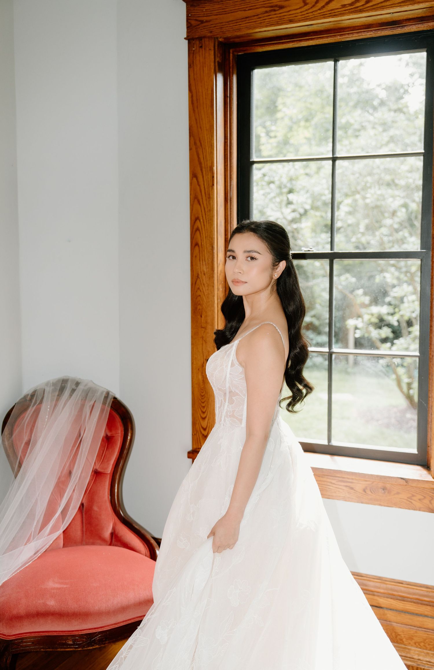 A bridal portrait series showing a flowing white wedding gown against rustic wood windows and coral accents.