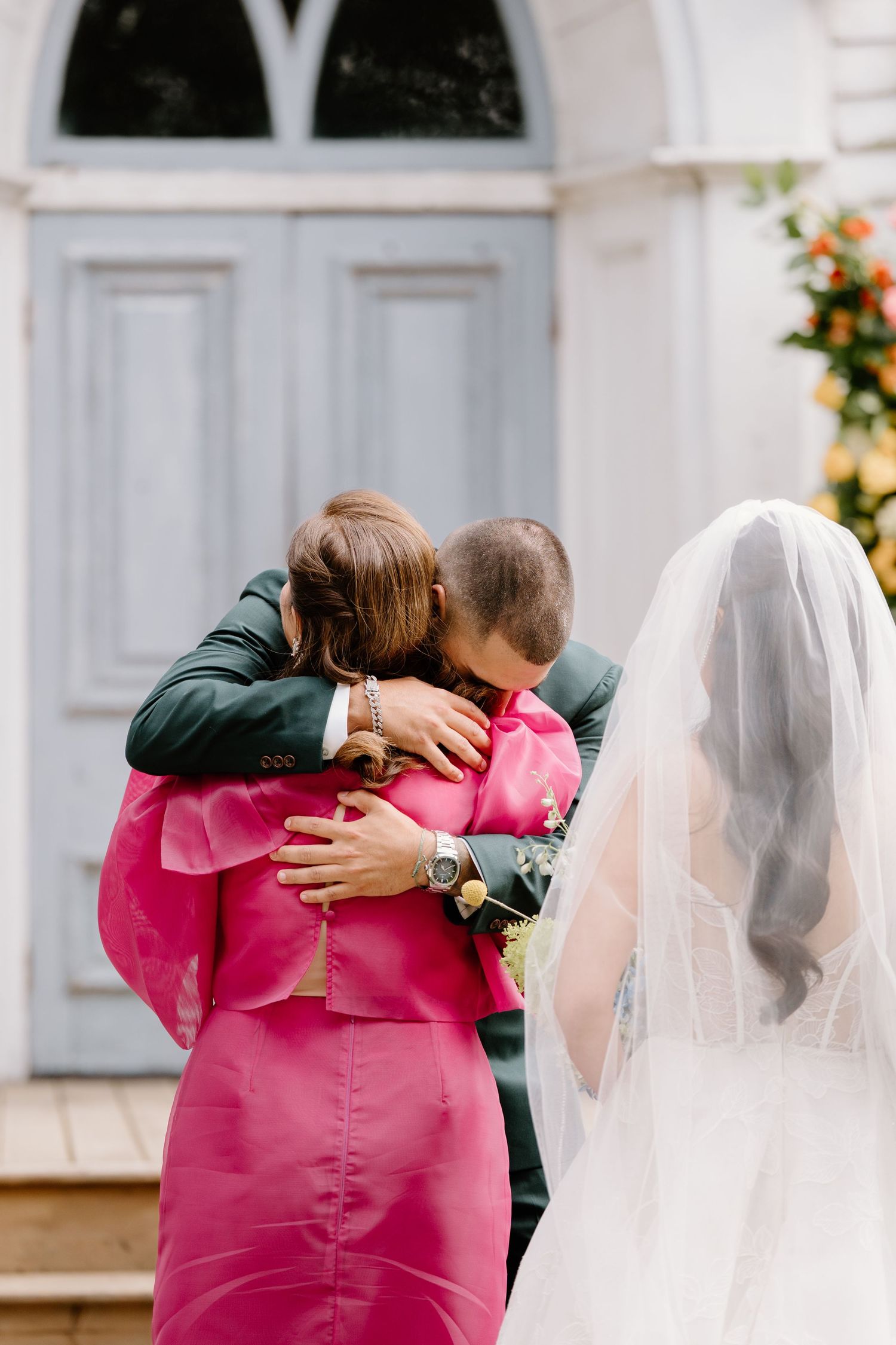 Sequence of wedding photos showing emotional embraces between people wearing pink and dark green attire.