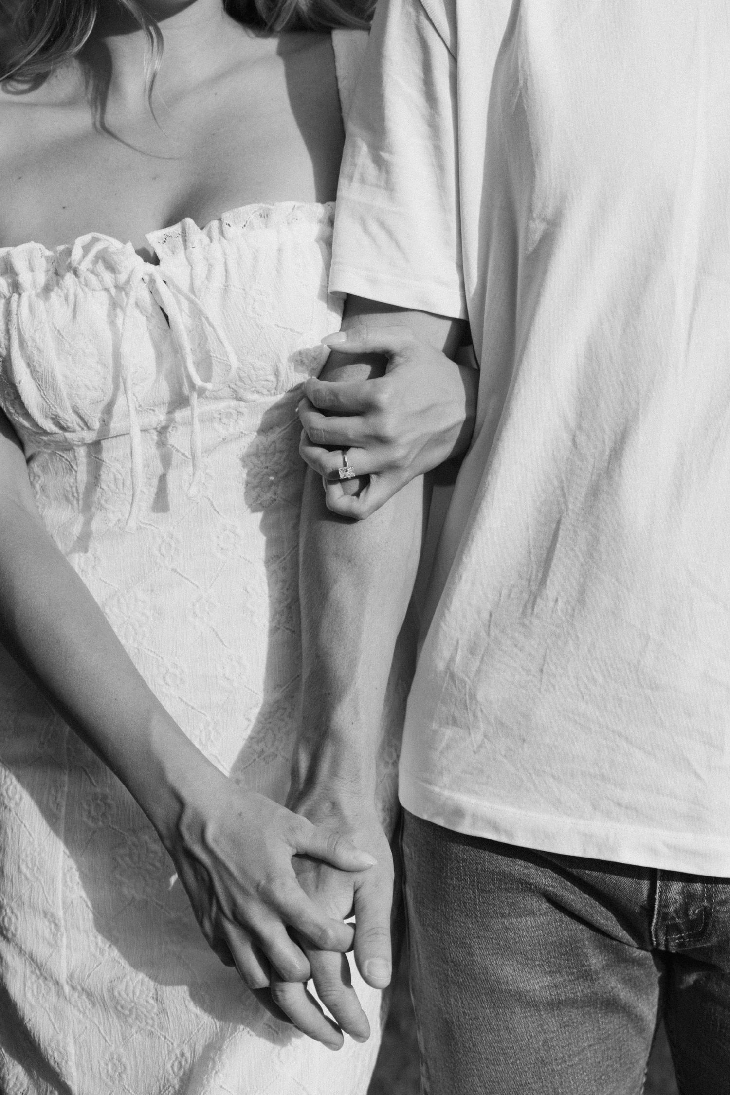 A series of black and white cropped photos showing hands holding and gently touching each other.