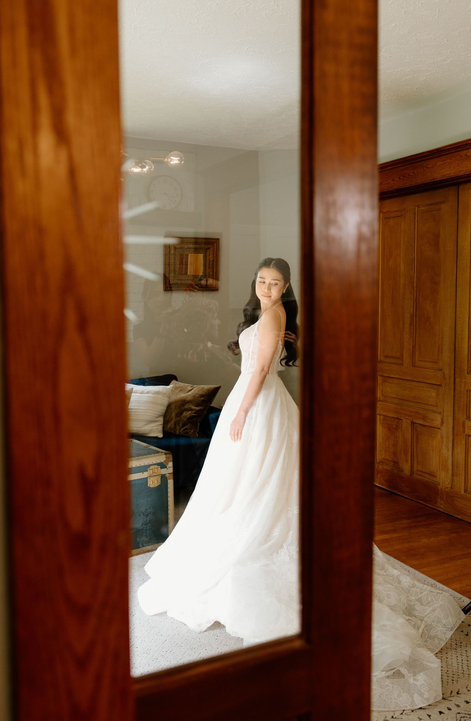 A sequence of wedding dress photos reflected in wood-framed mirrors showing different angles of the gown.
