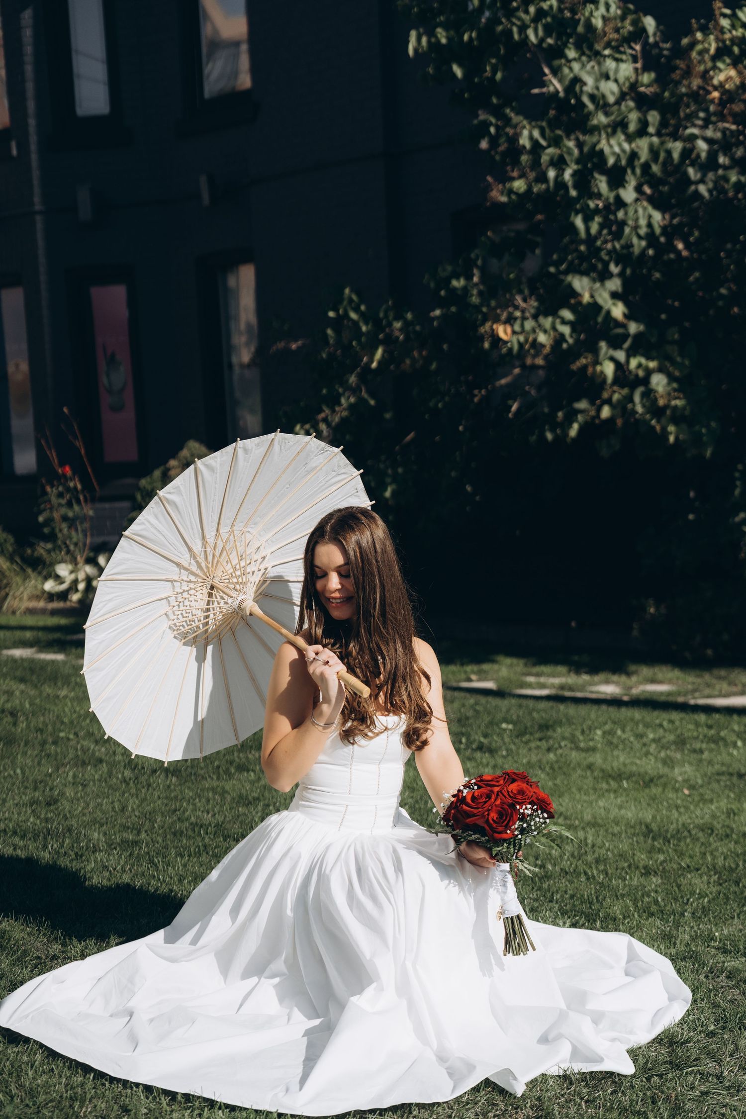 Four artistic photos of a bride in a white dress with a vintage parasol posing gracefully on grass in the sunshine.