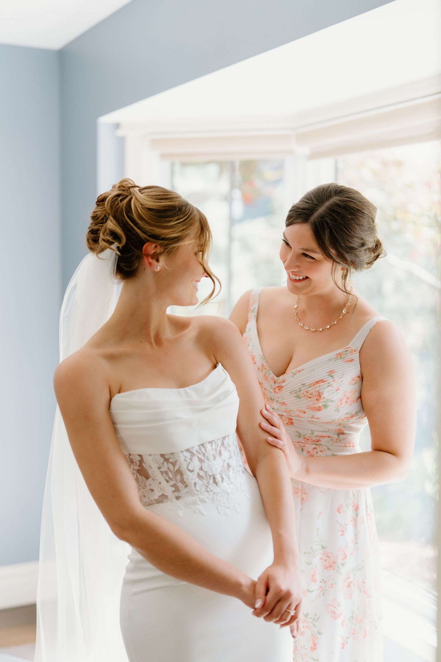Two people in white dresses share a joyful moment together during a wedding celebration.