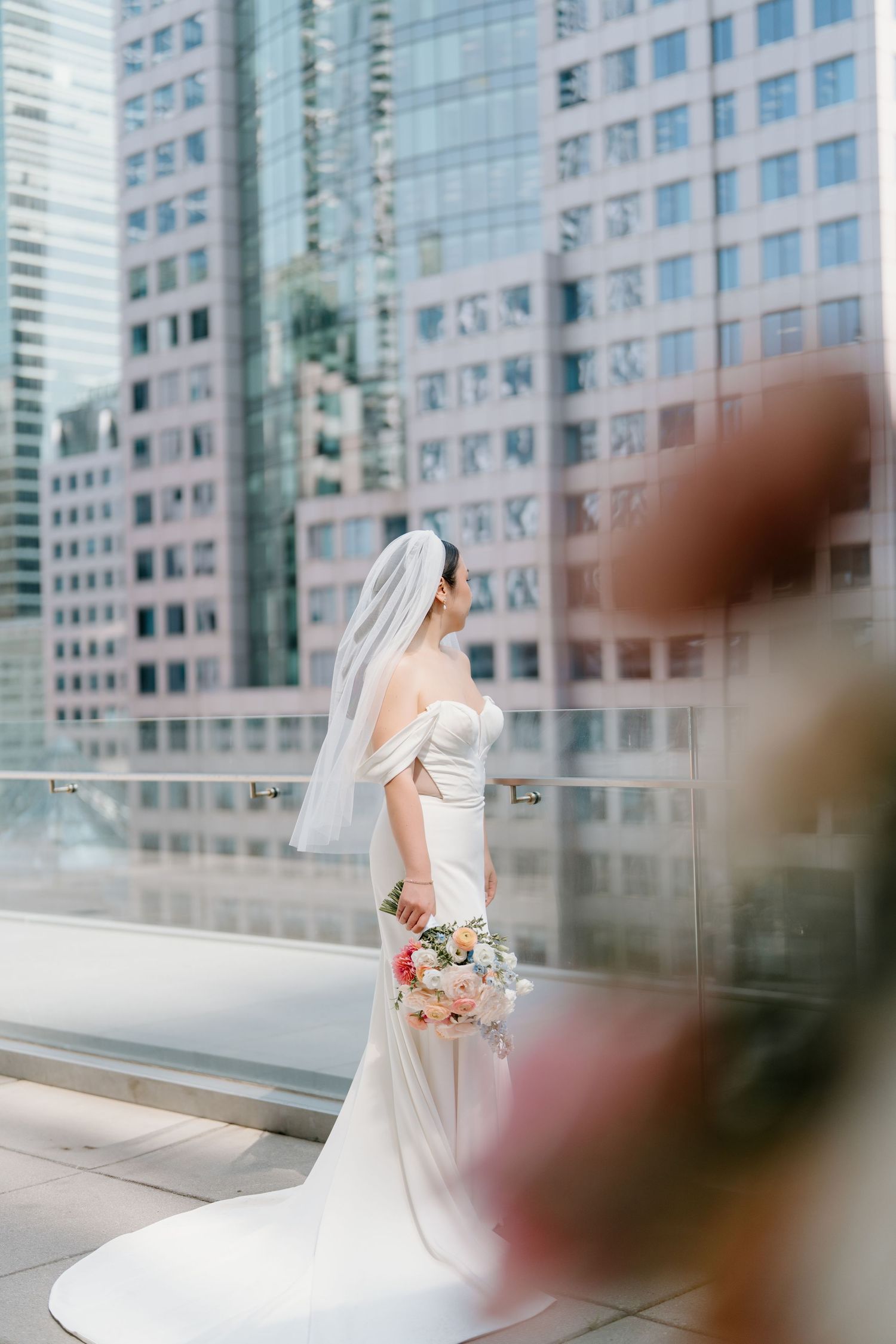 A bridal photo series in front of modern glass office buildings showing a flowing white wedding dress at different angles.