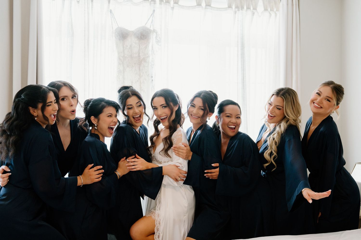 A group of people wearing black and white formal attire gather together in a row for a special occasion.