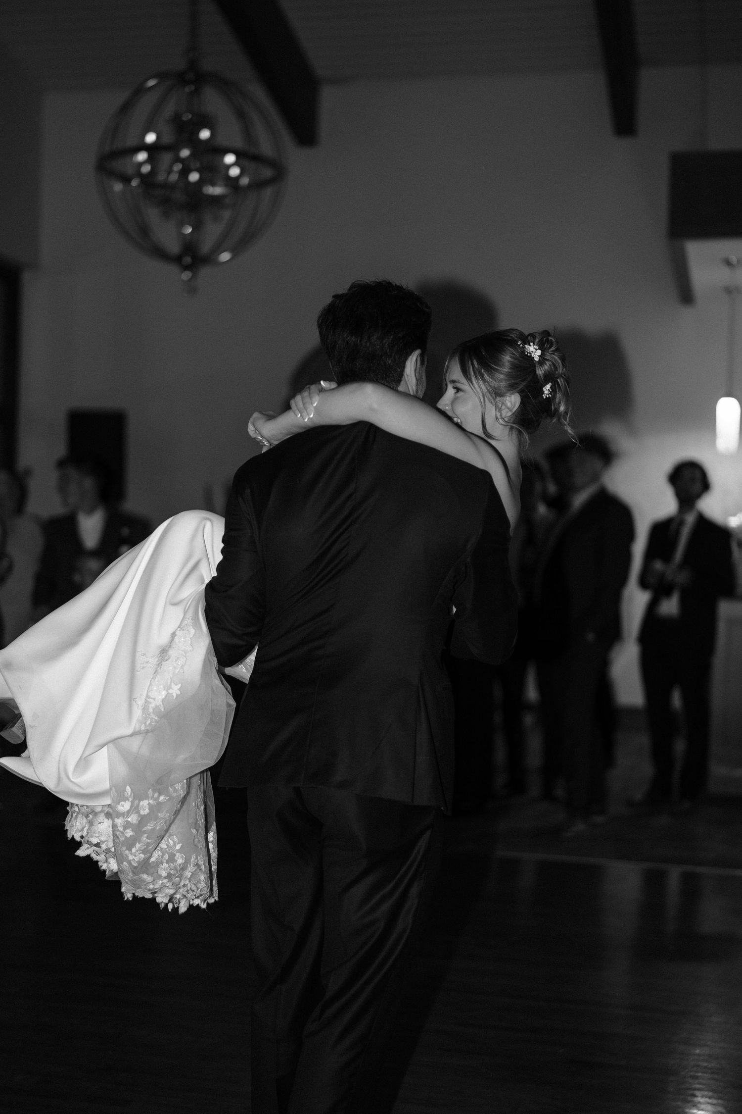 A couple performs a dramatic dance dip during their first dance at a wedding reception.