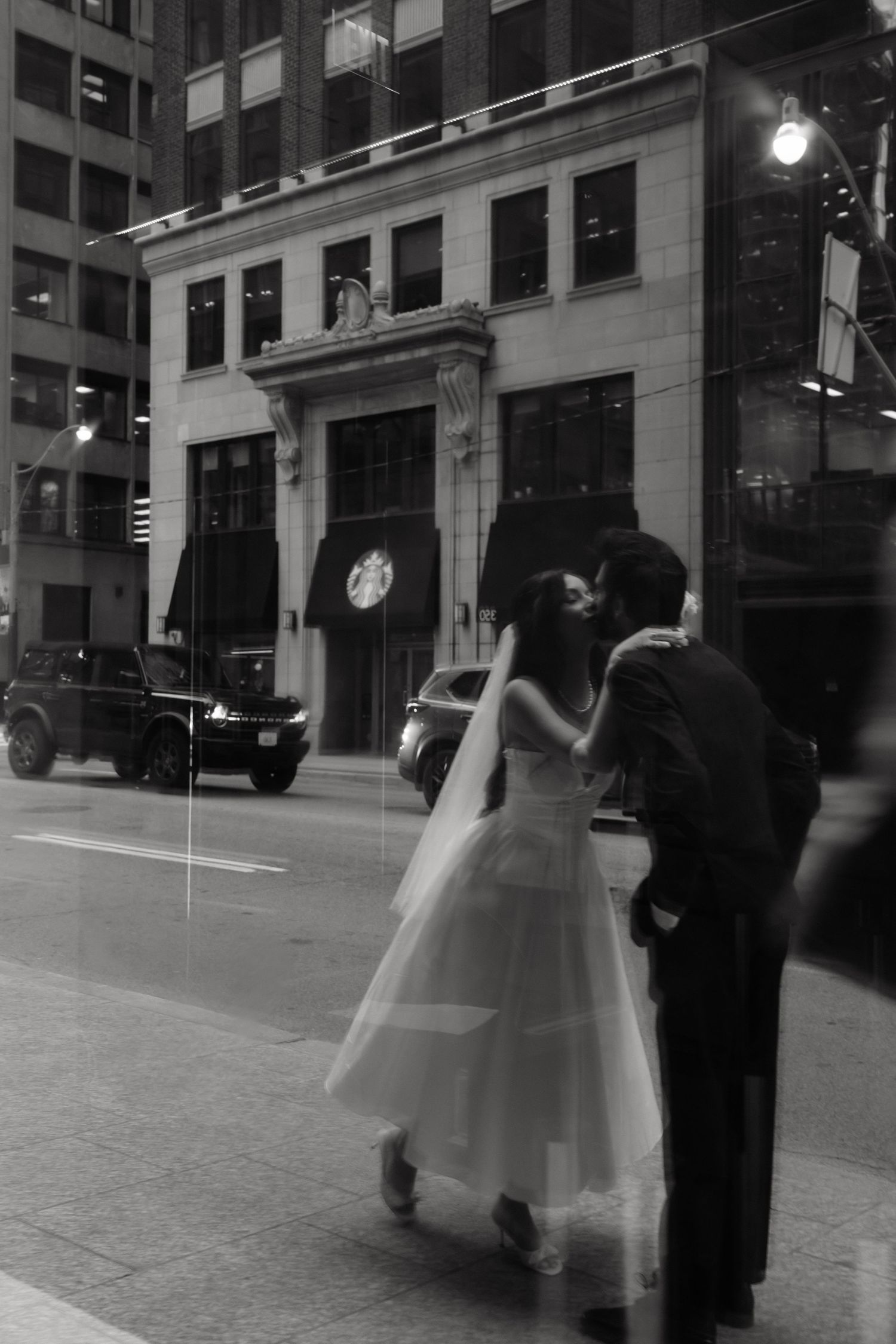 A blurred black and white photo Romantic embrace between bride and groom during sunset captured by AZ Photo Studio
