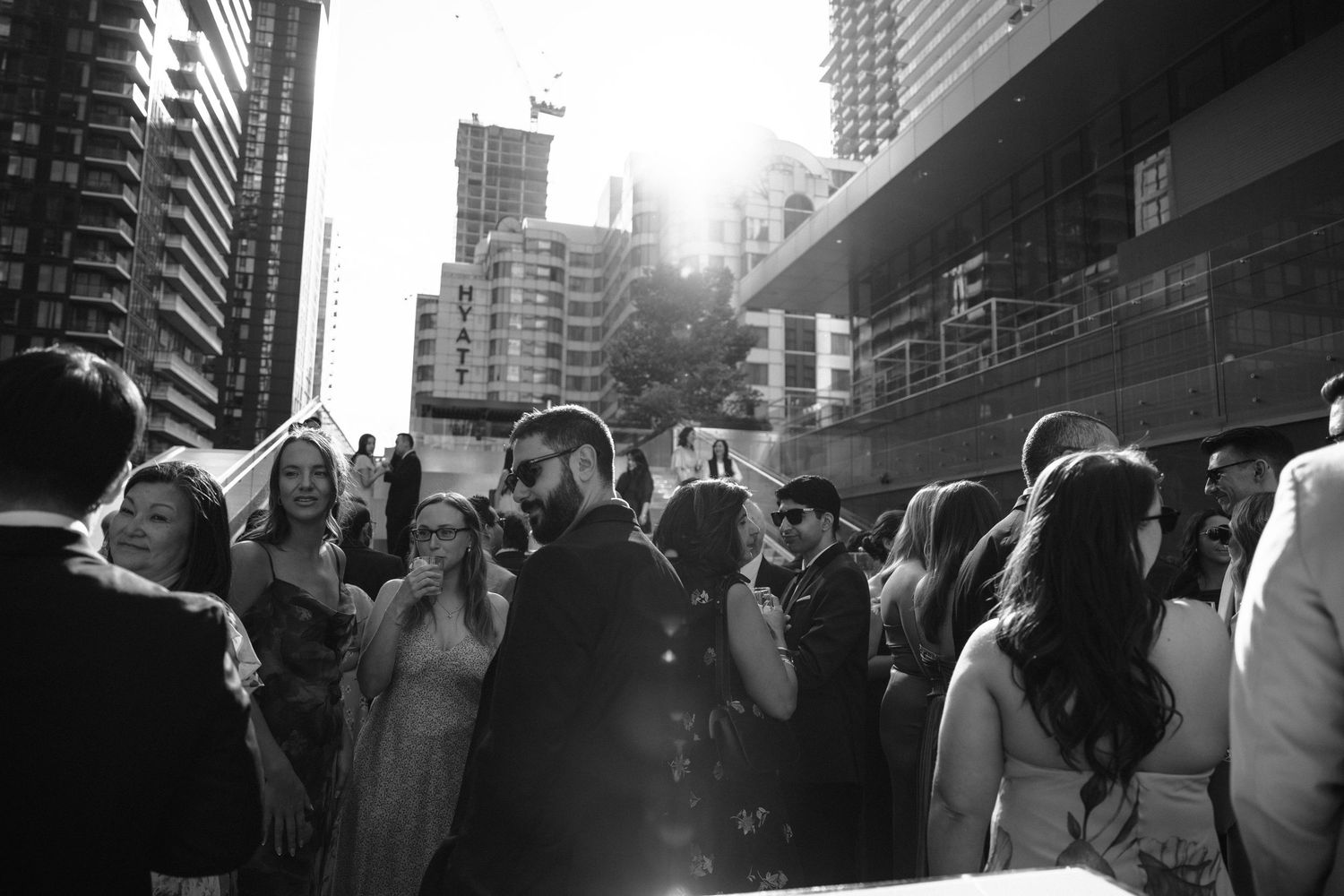 People crowd the streets of a big city at night, creating a bustling urban atmosphere with tall buildings in the background.