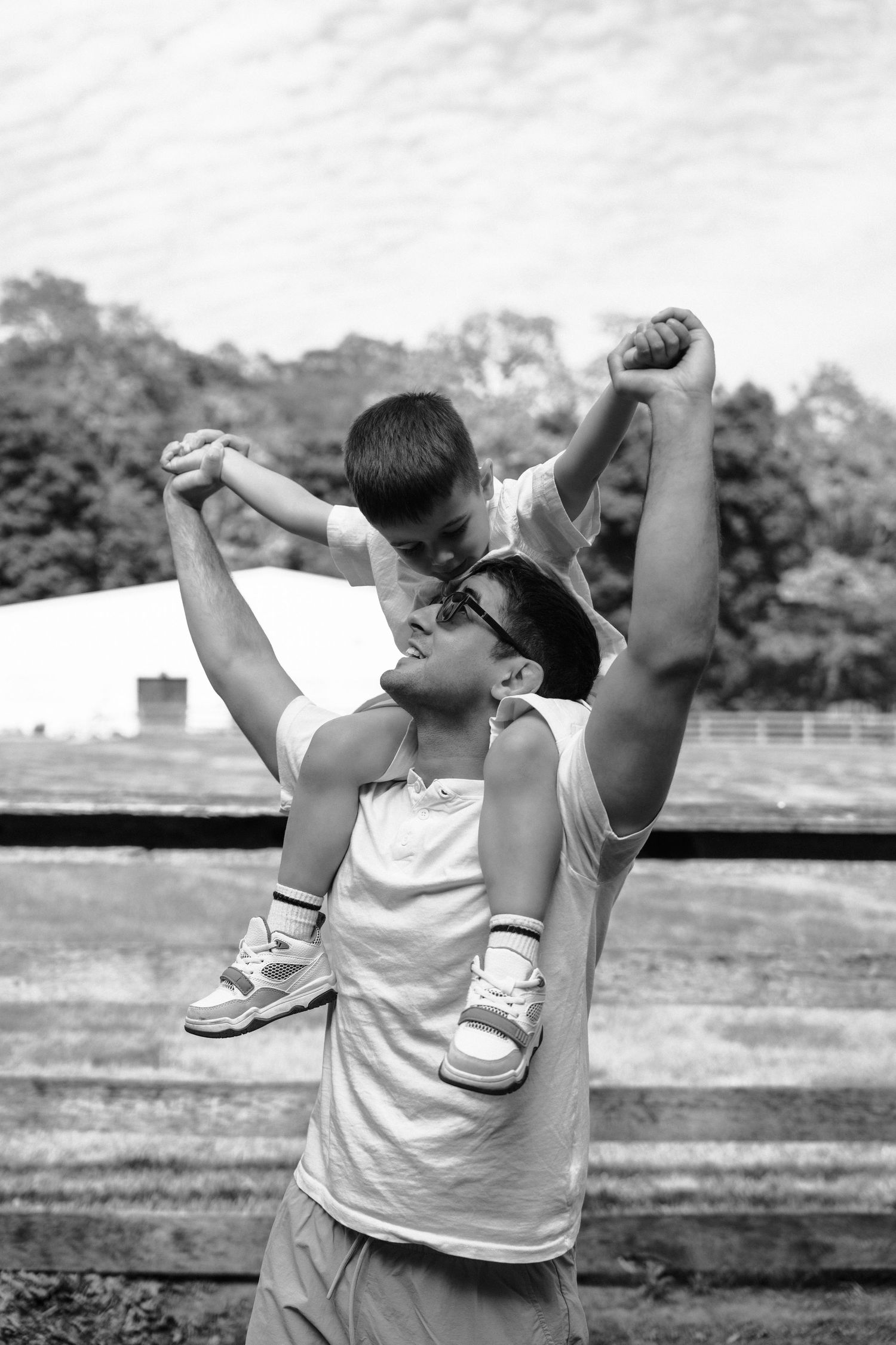 Three sequential black and white images show someone in a white tank top demonstrating a dab dance move outdoors.