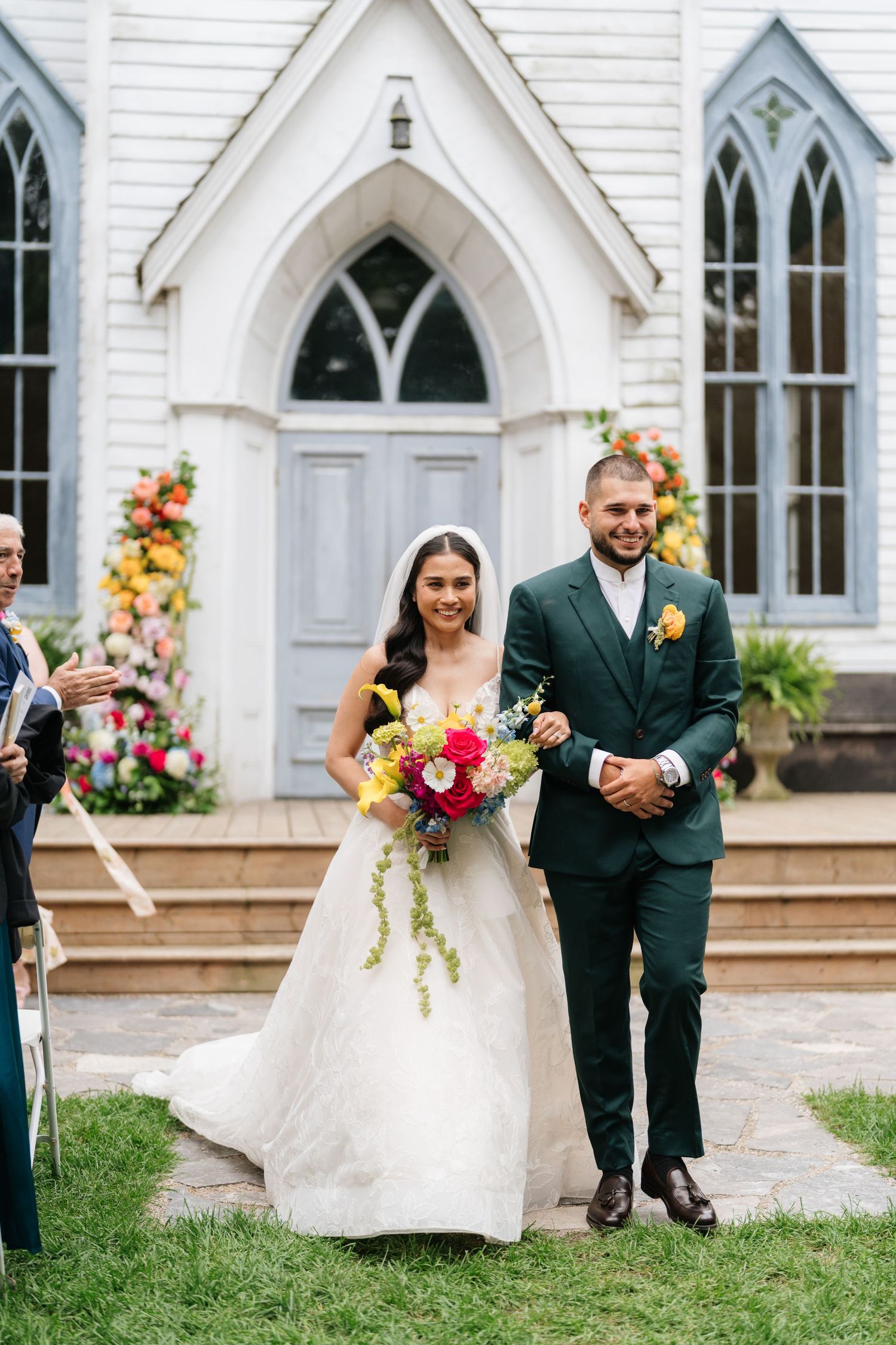 A wedding processional with three views of a couple walking arm in arm outside a white Gothic-style church with arched windows.