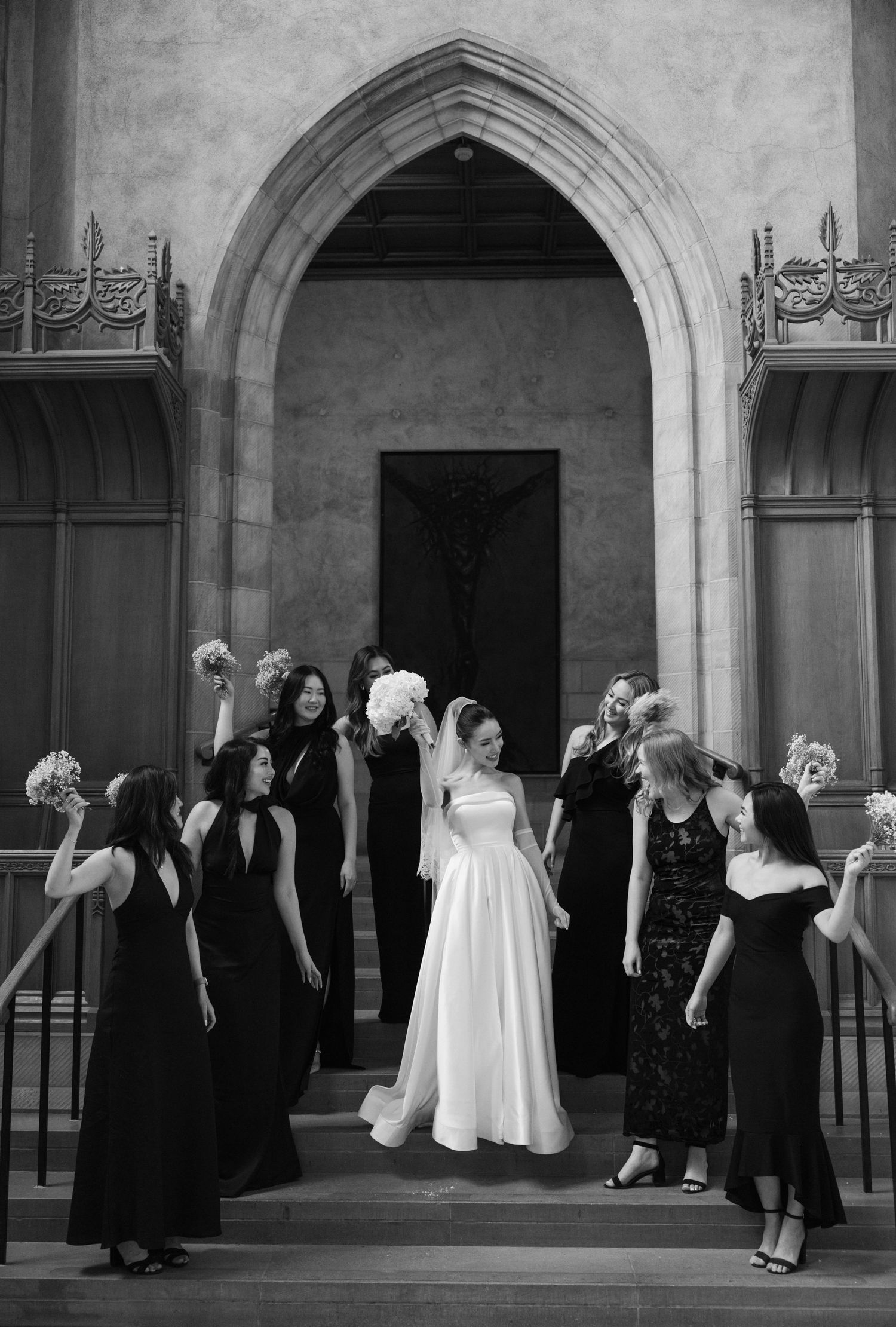 Black and white wedding party gathers under Gothic arches in a series of four connected photographs.