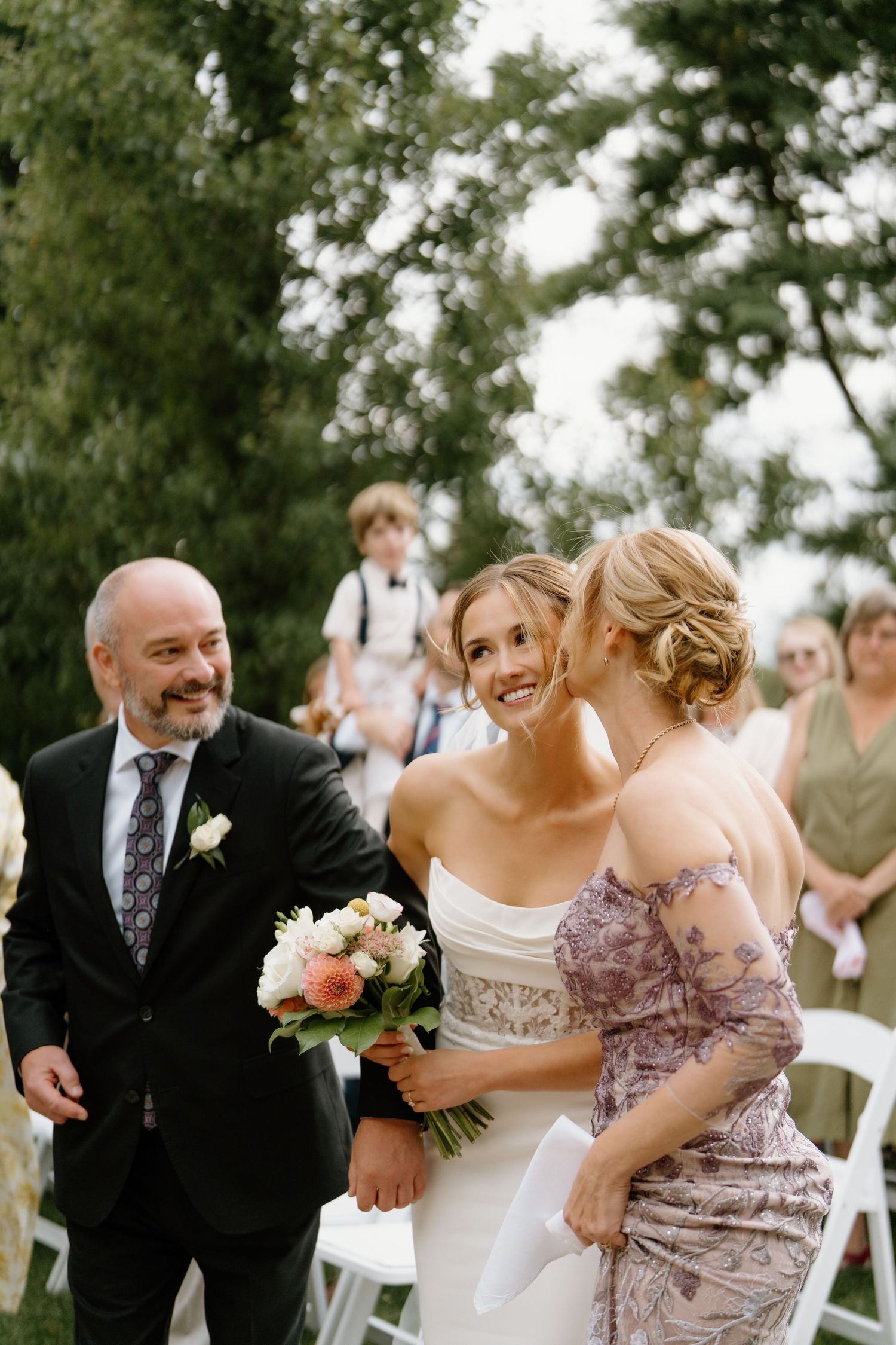 A candid sequence of joyful moments at an outdoor wedding celebration with guests sharing laughter and embraces.