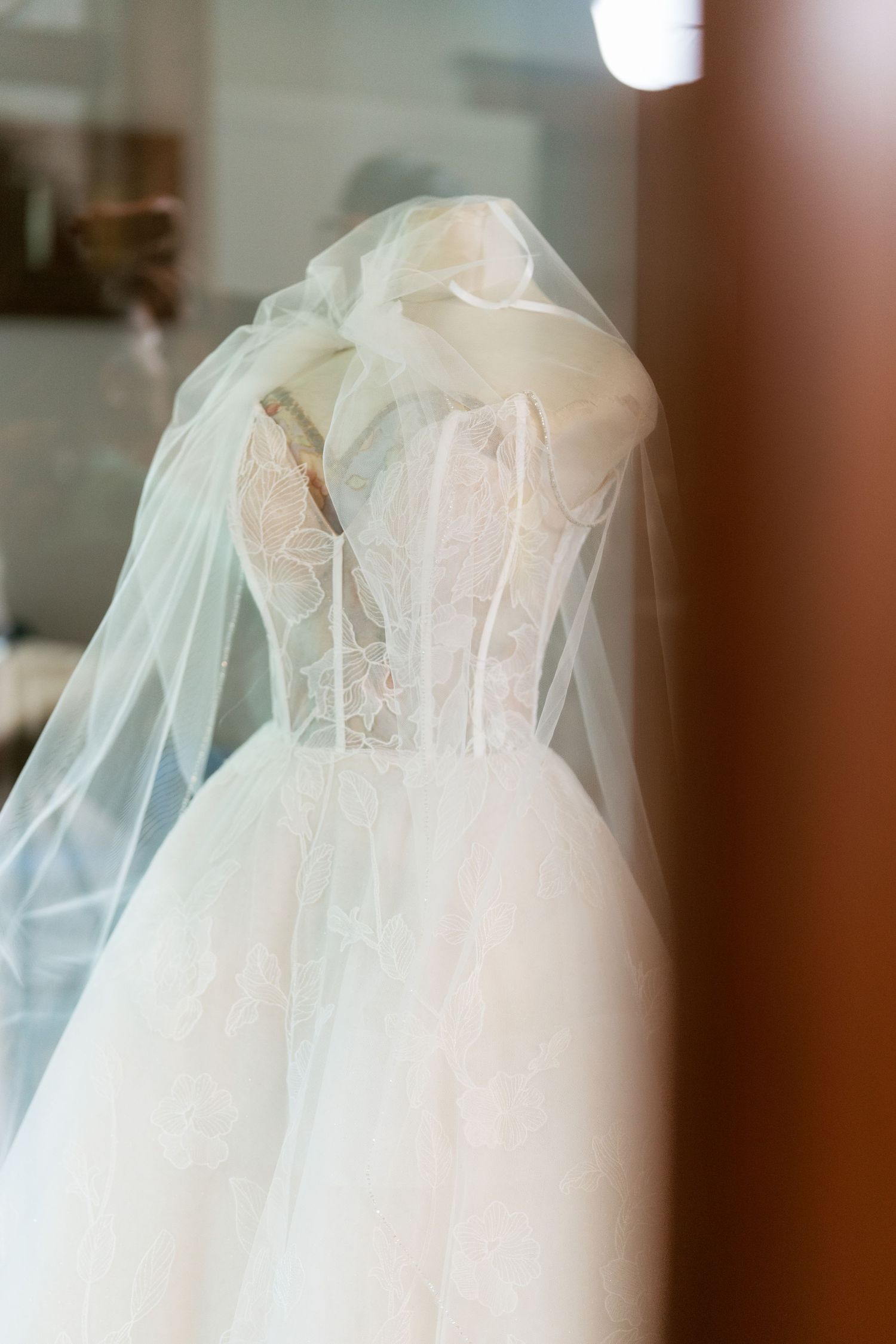 A close-up view of delicate white tulle fabric details on a wedding dress, shown from different angles.