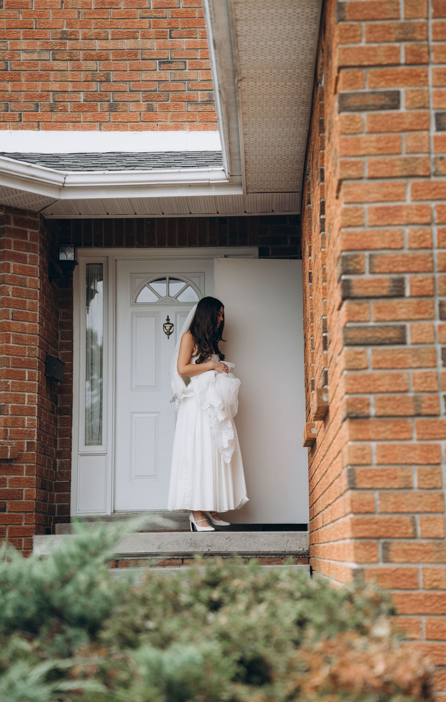 A series of doorway shots showing white door entrance against red brick walls with partial view of green landscaping.