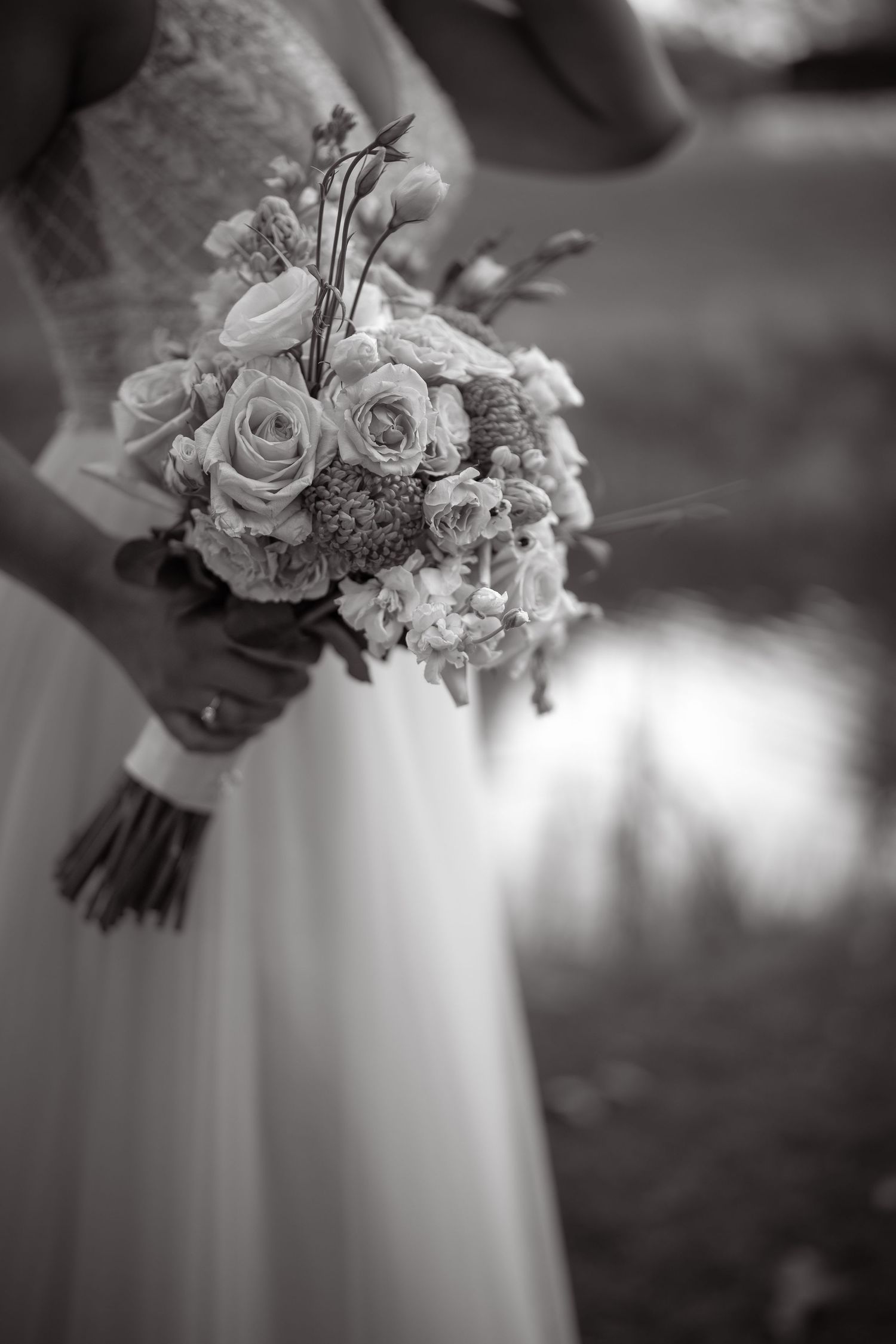 Black and white detail shot of wedding bouquet with roses and mixed flowers.