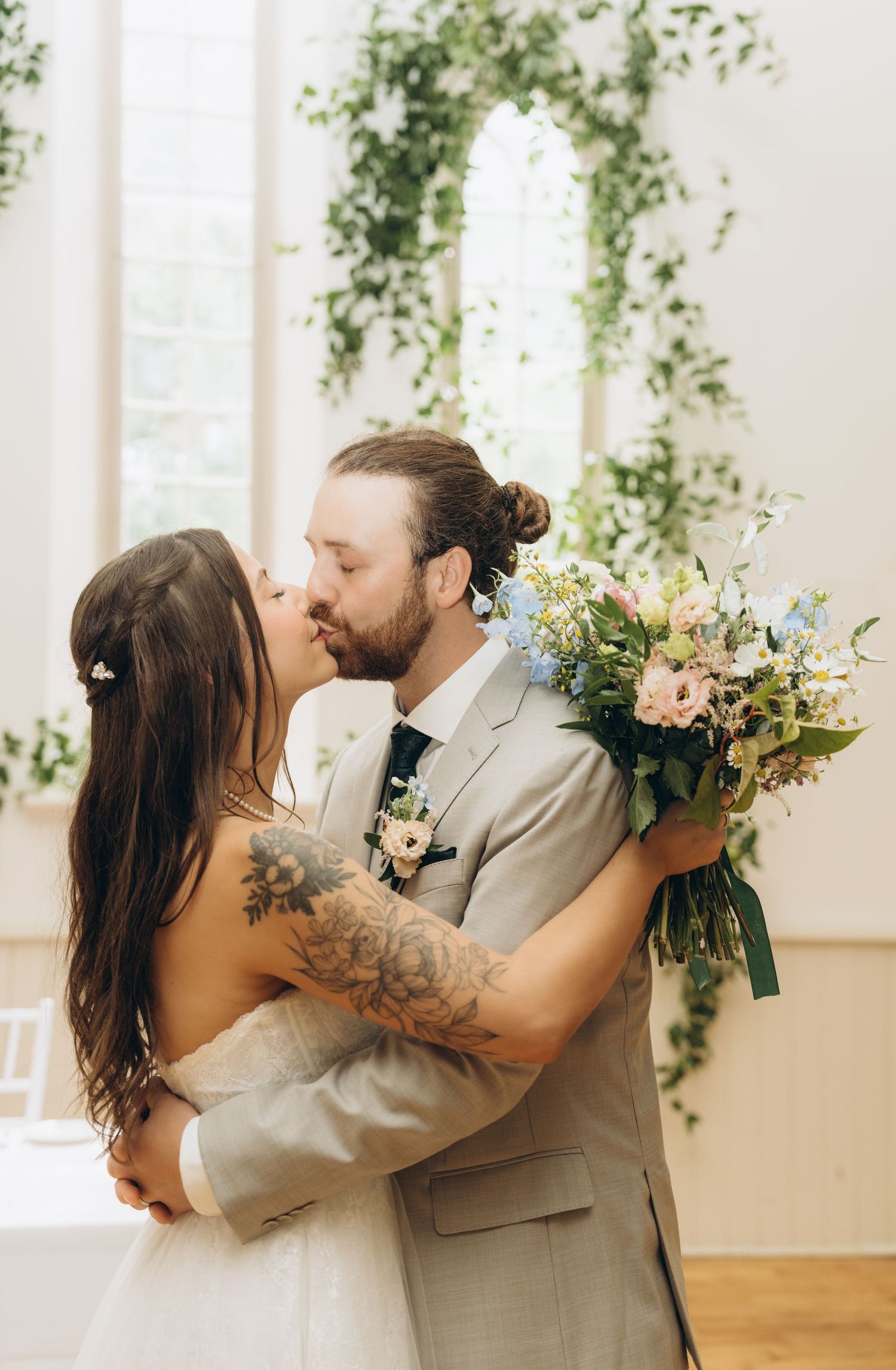 A romantic wedding moment captured in three sequential photos showing a couple embracing and kissing in a light-filled venue.
