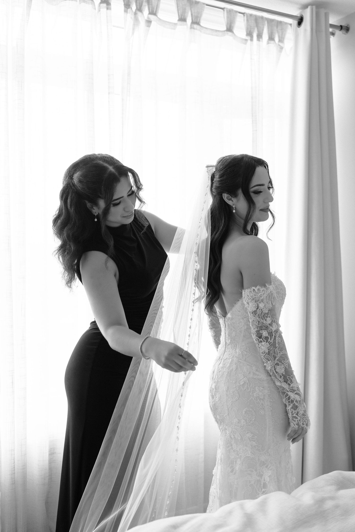 A series of black and white photos showing intimate moments during wedding preparations near sunlit windows.