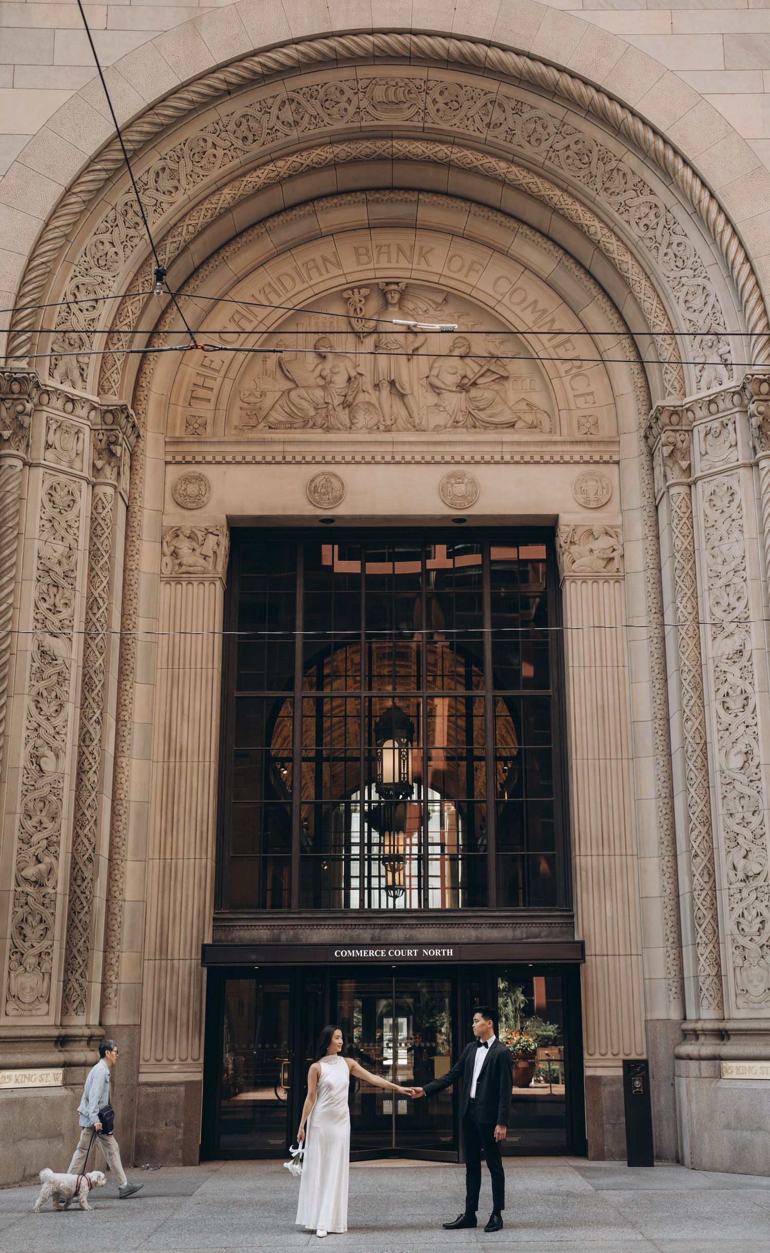 An ornate arched entrance of a historic building with elaborate stone carvings and decorative details above iron gates.