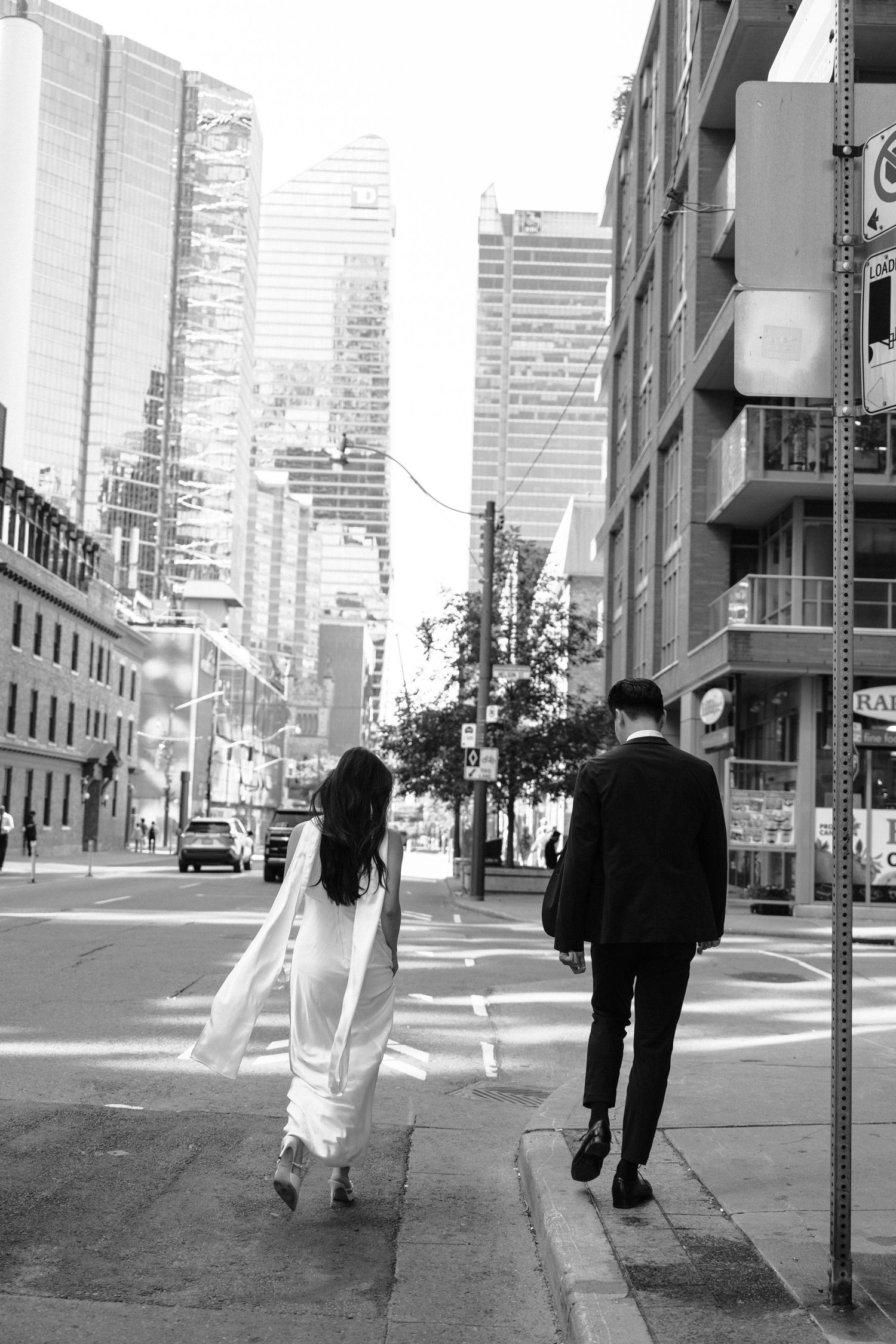 Black and white photo series showing pedestrians walking on an urban street with skyscrapers in the background.