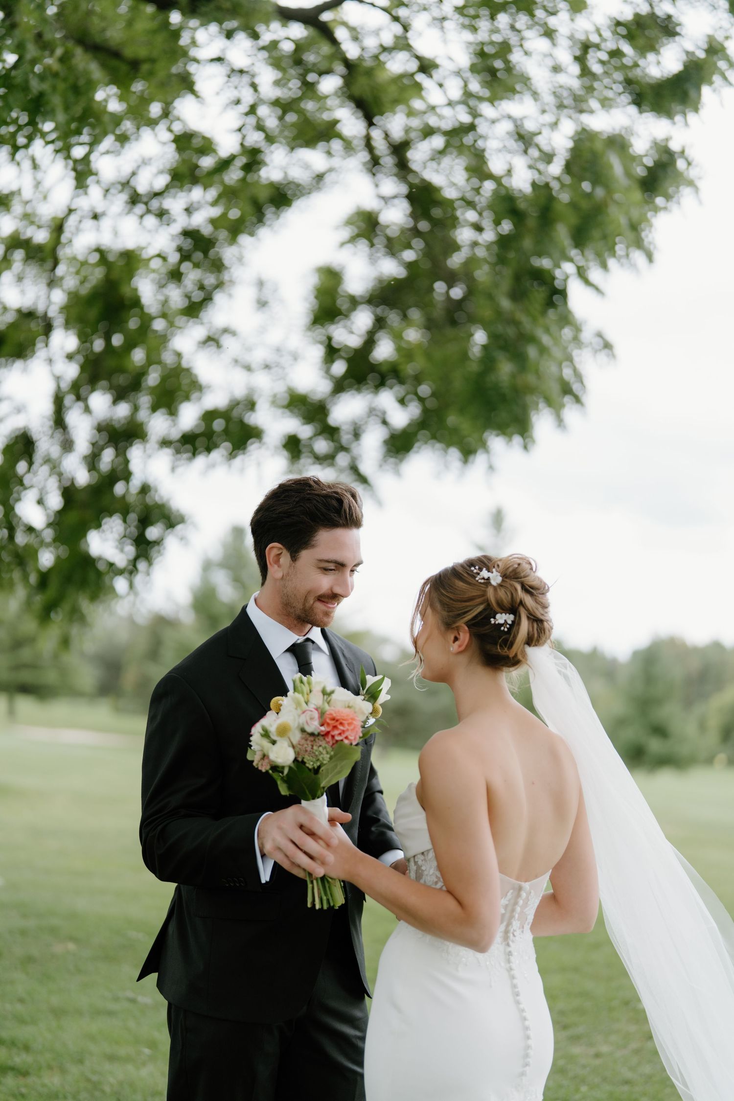 A romantic outdoor wedding photoshoot in a lush green park setting.