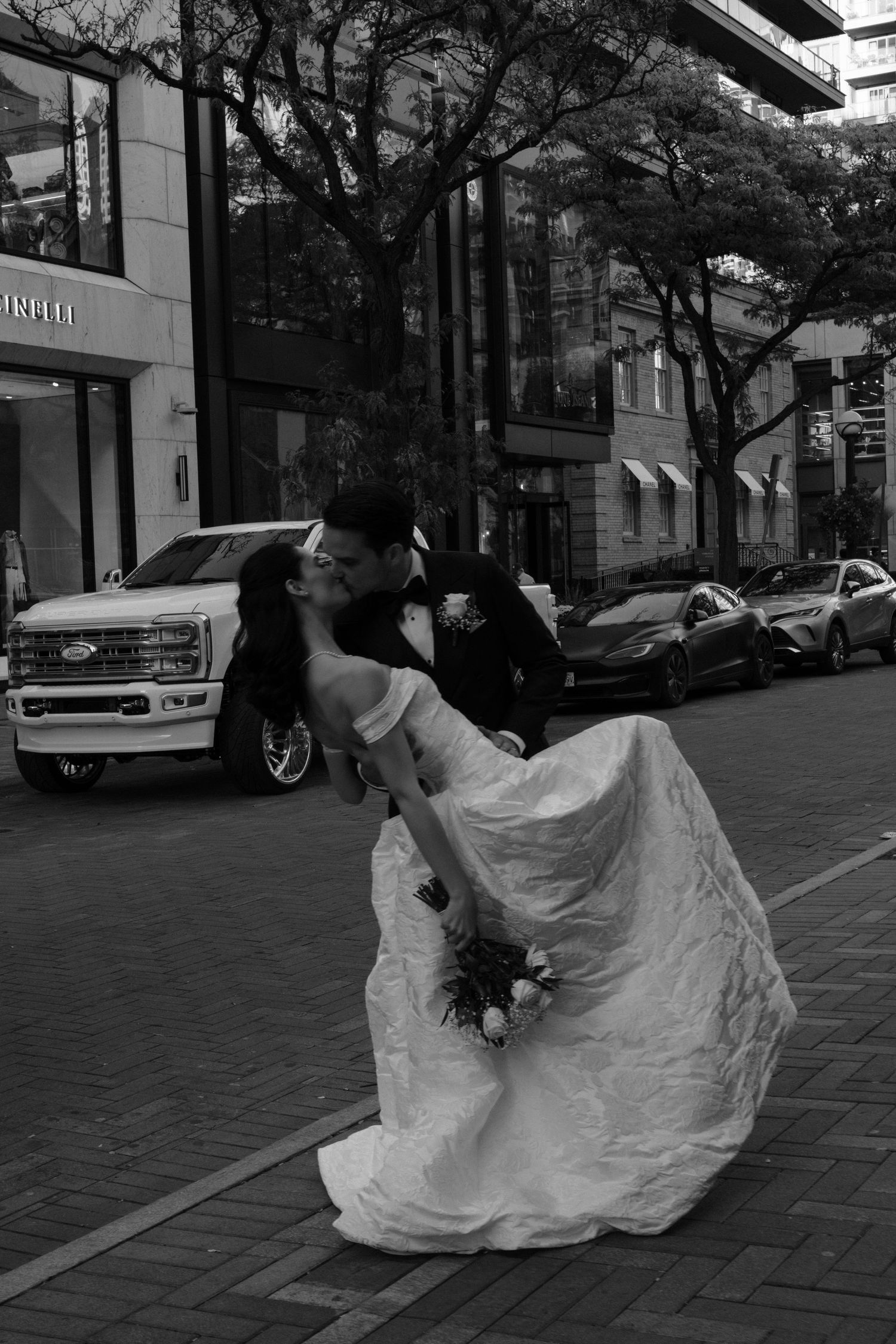 A black and white photo sequence shows a couple in wedding attire dancing gracefully on a city street.