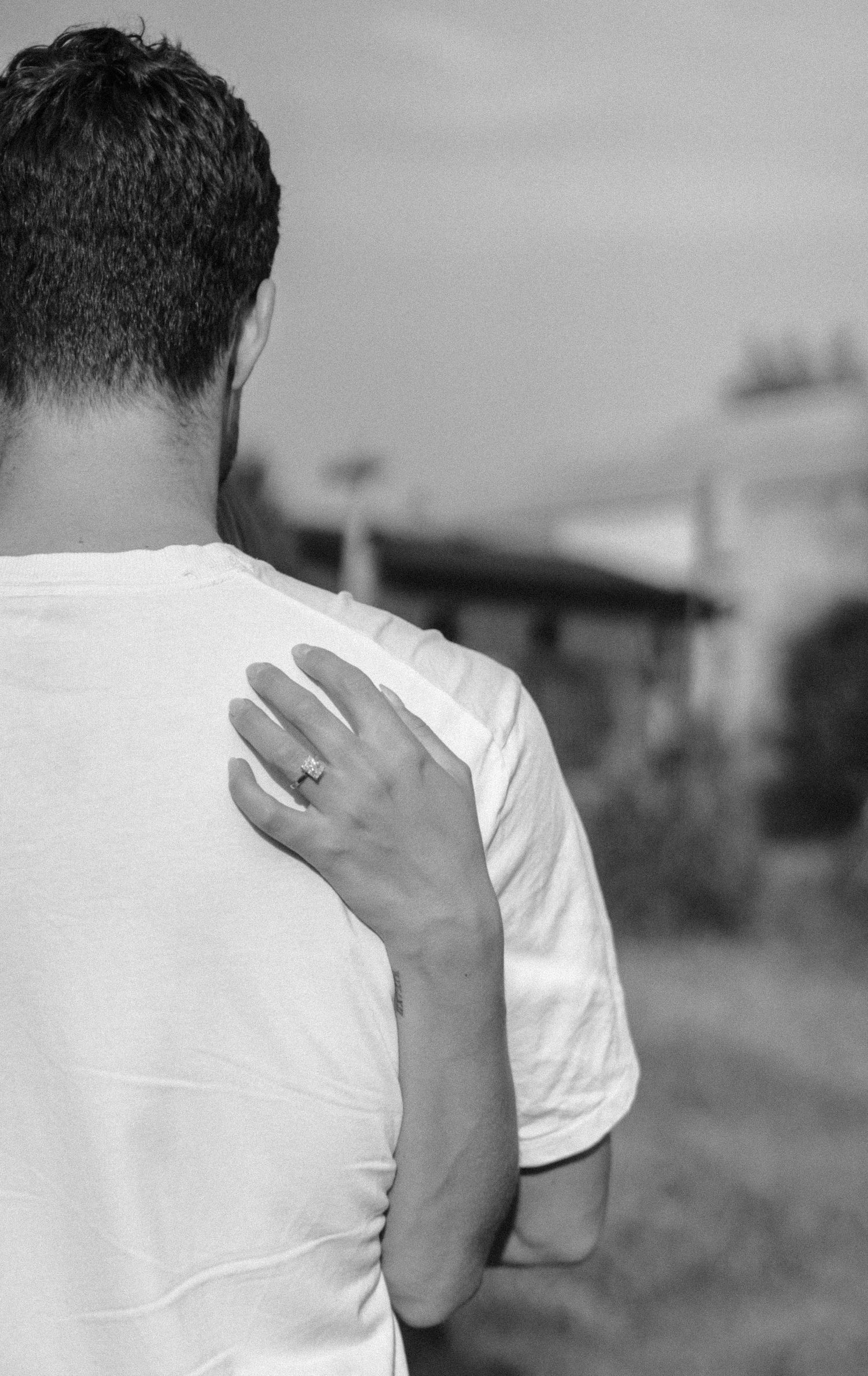 A person in a white t-shirt covers their face with their hand in a black and white photo sequence.