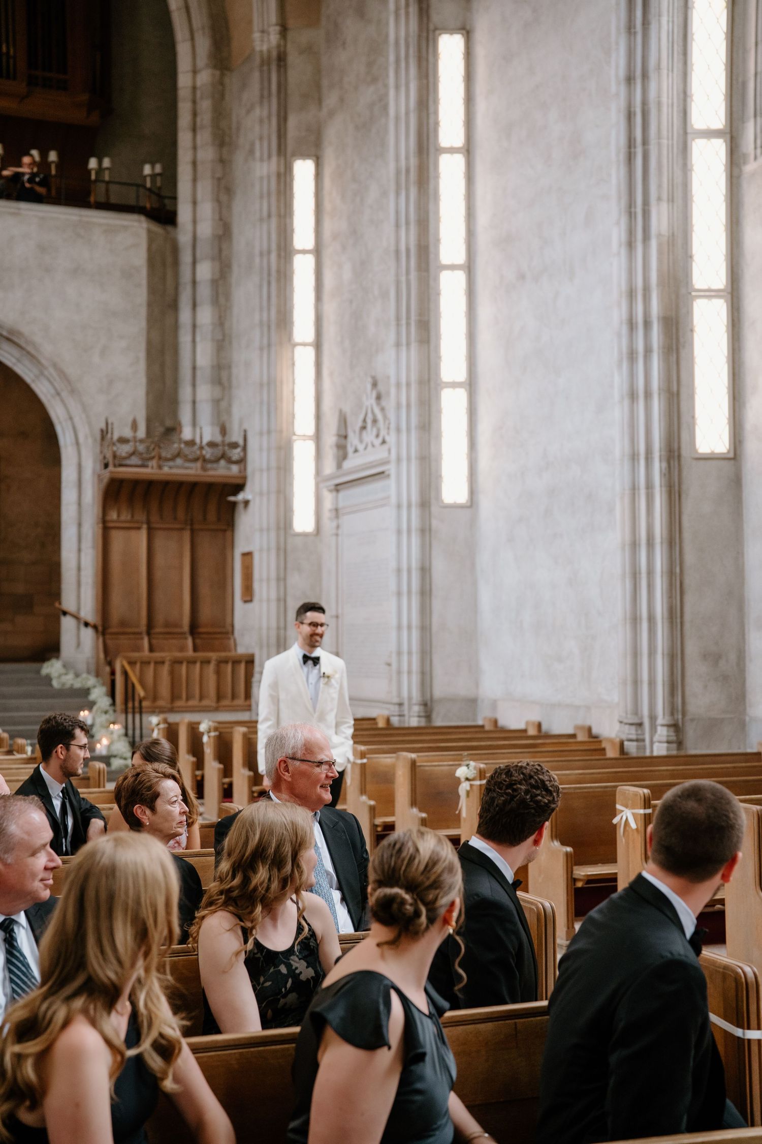 A formal wedding ceremony in a grand cathedral with high ceilings and vertical windows.