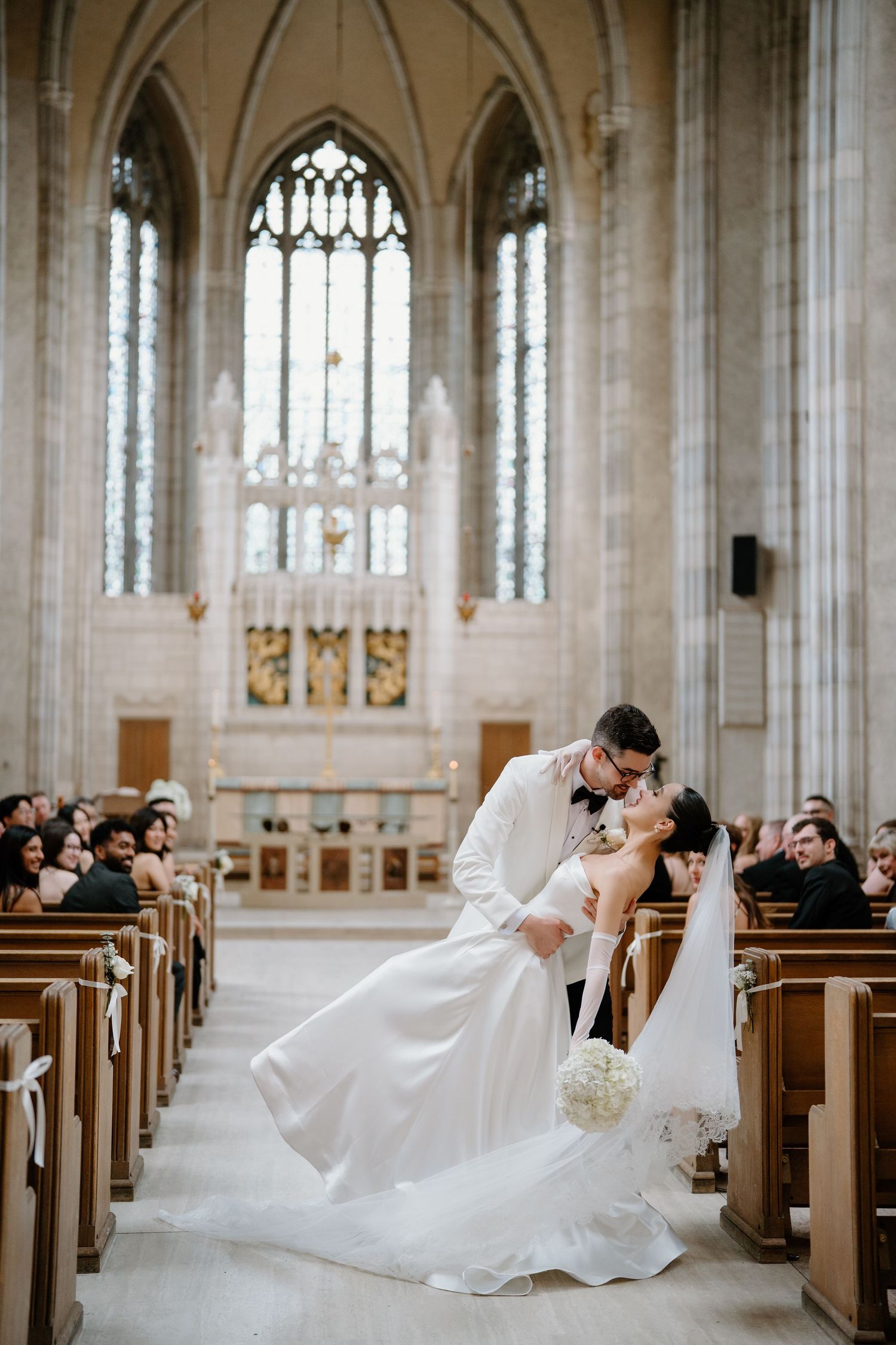 Series of romantic poses in gothic church with vaulted ceilings and stained glass windows.