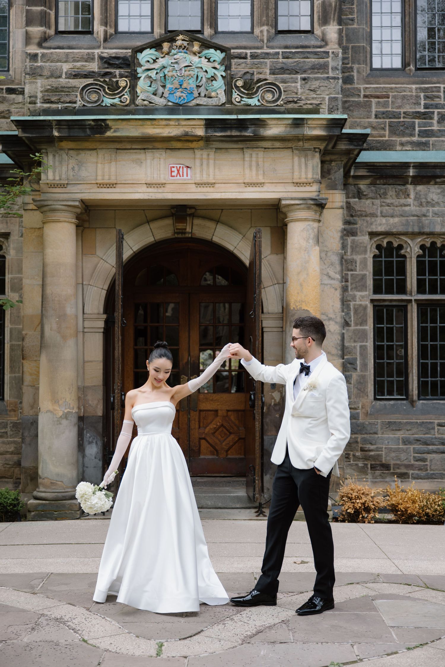 A series of wedding photos showing a couple dancing and twirling in front of a stone building with elegant architecture.