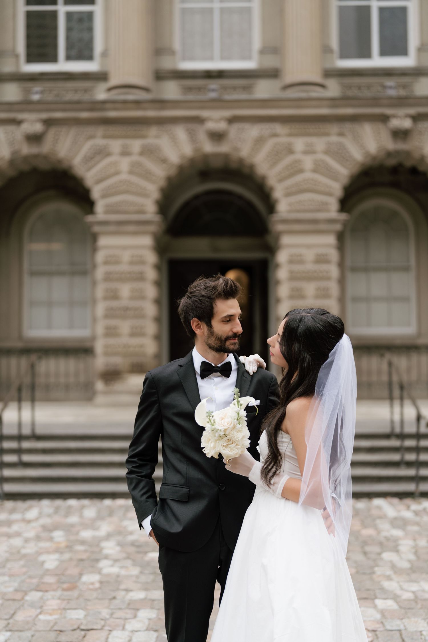 A romantic wedding photo sequence showing a couple sharing a tender kiss in front of Osgood hall captured by AZ photo studio