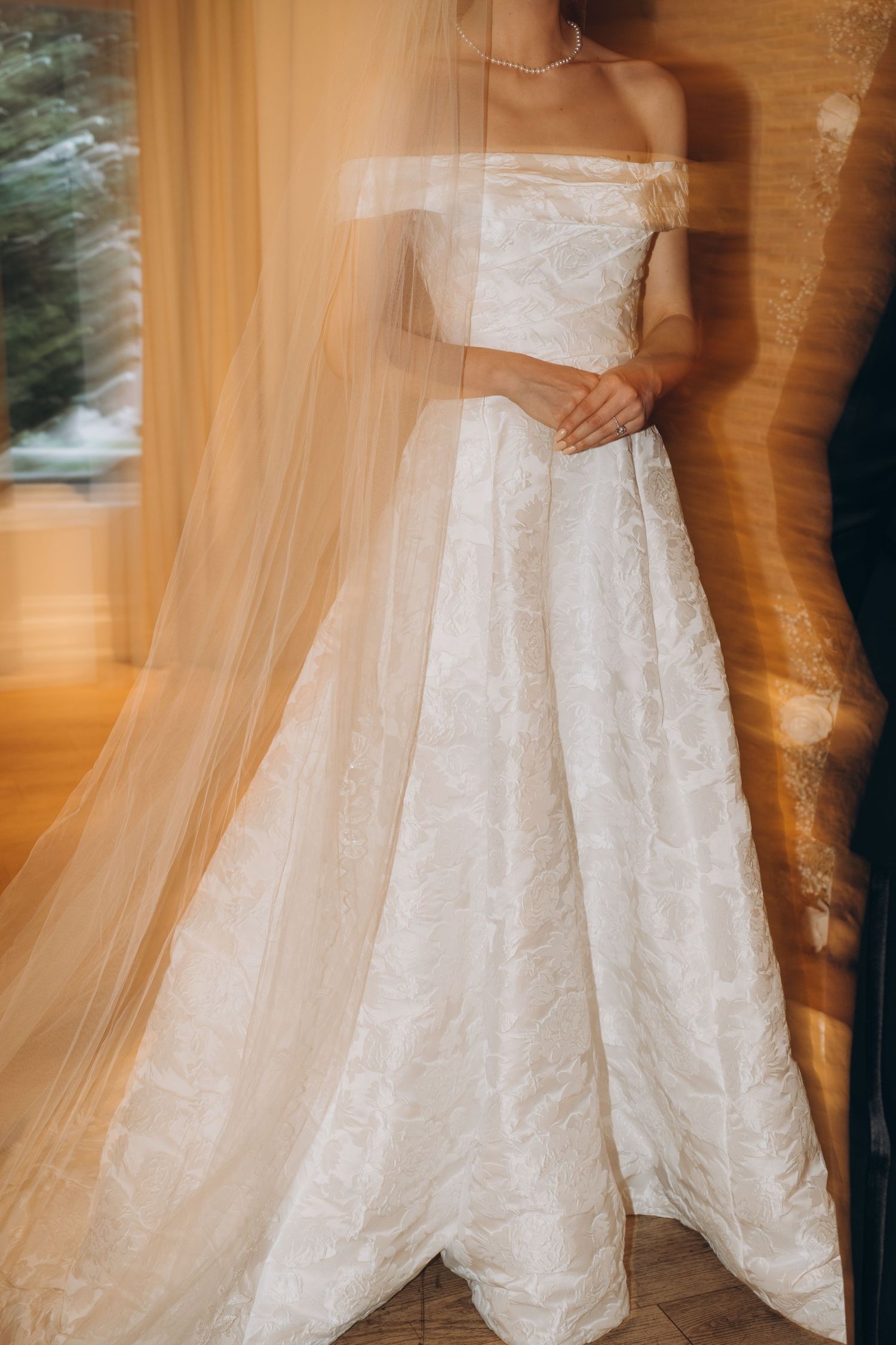 Close-up details of a white lace wedding dress with intricate embroidery patterns and delicate fabric texture.