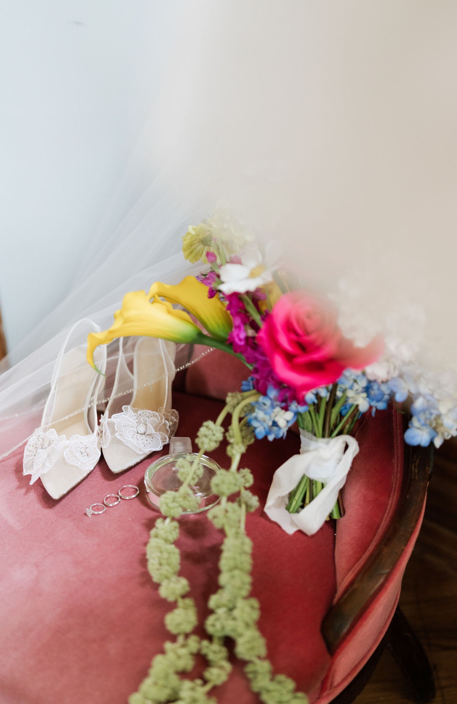 A sequence of four progressive images showing colorful flowers and ribbons being arranged on a reddish surface.
