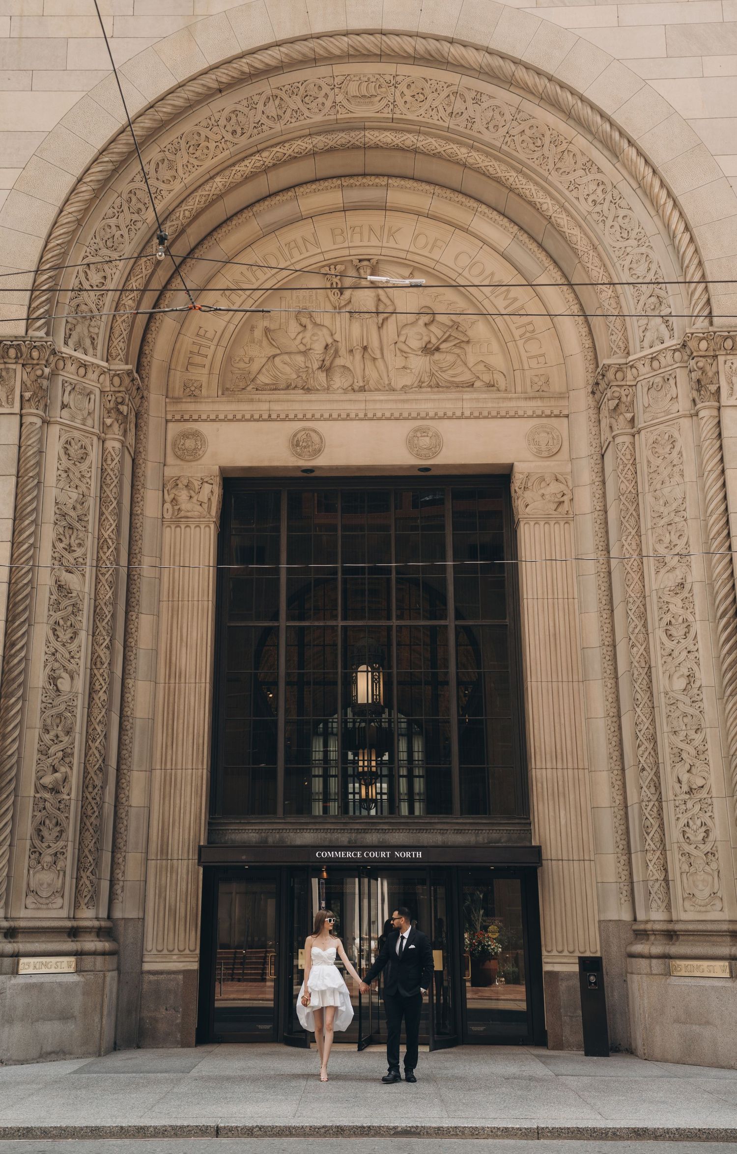Ornate stone archways with intricate carved details frame entrances to a grand classical building.