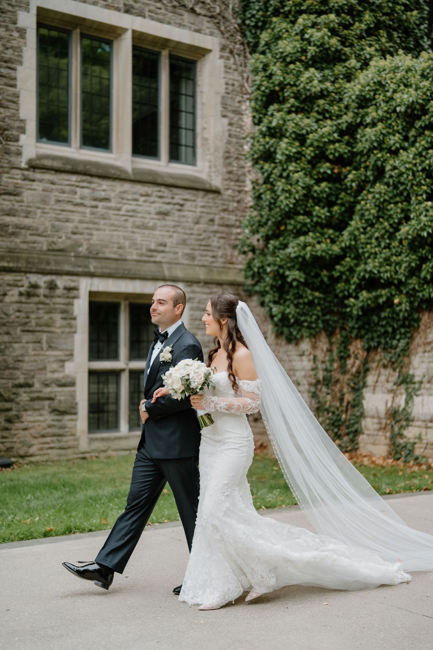 Wedding photo series capturing a couple's movement along a stone walkway near an elegant building.