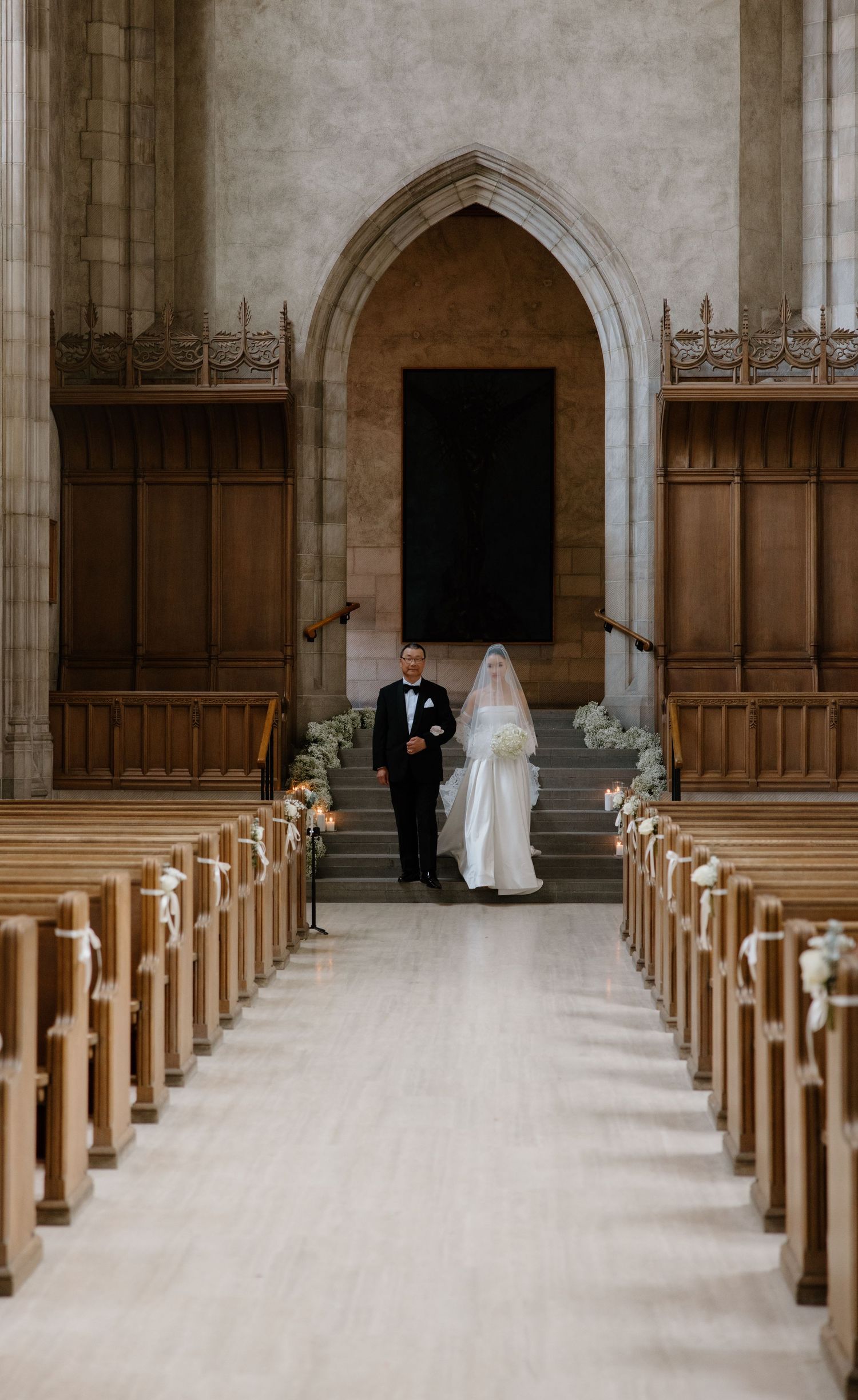 A panoramic view of an empty church interior with wooden pews and gothic arches during a wedding ceremony.