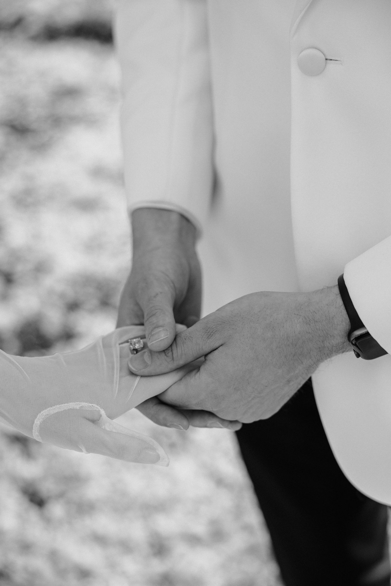 A black and white series of photos showing hands exchanging wedding rings during a romantic marriage ceremony.