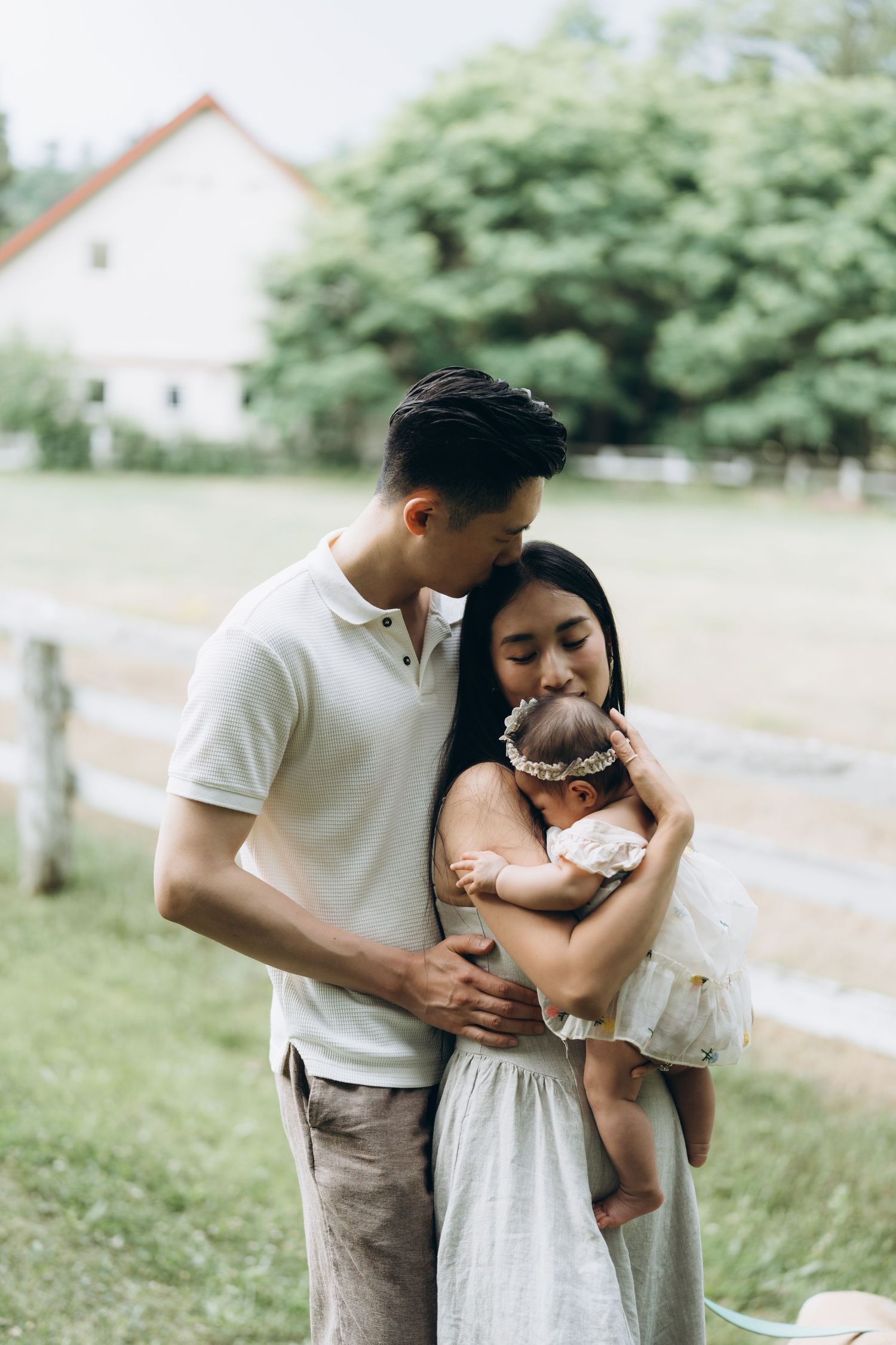 Intimate outdoor couple photos capture a romantic embrace in a natural setting with white and beige outfits on a sunny summer day.