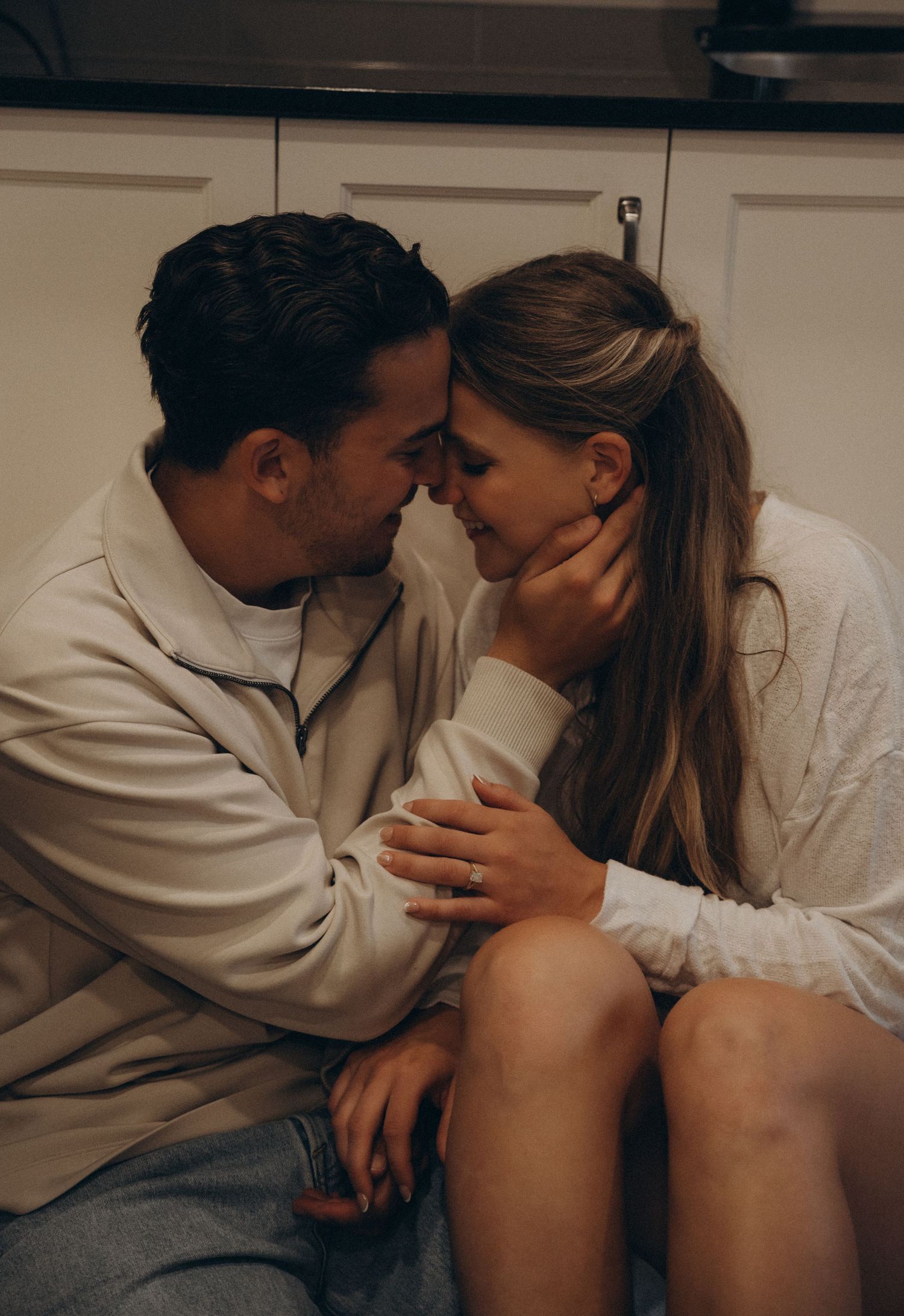 A sequence of dimly lit intimate photographs showing two people sitting close together on a couch.