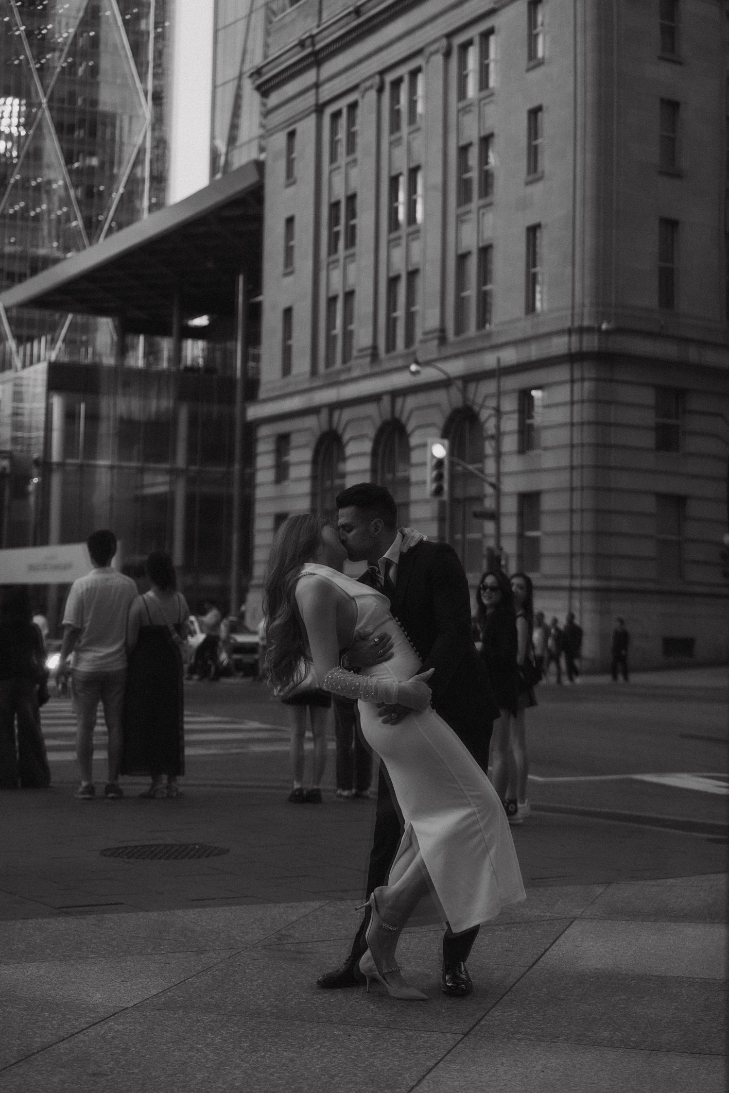 A black and white photo sequence showing a backlit figure in motion against an urban backdrop of buildings.